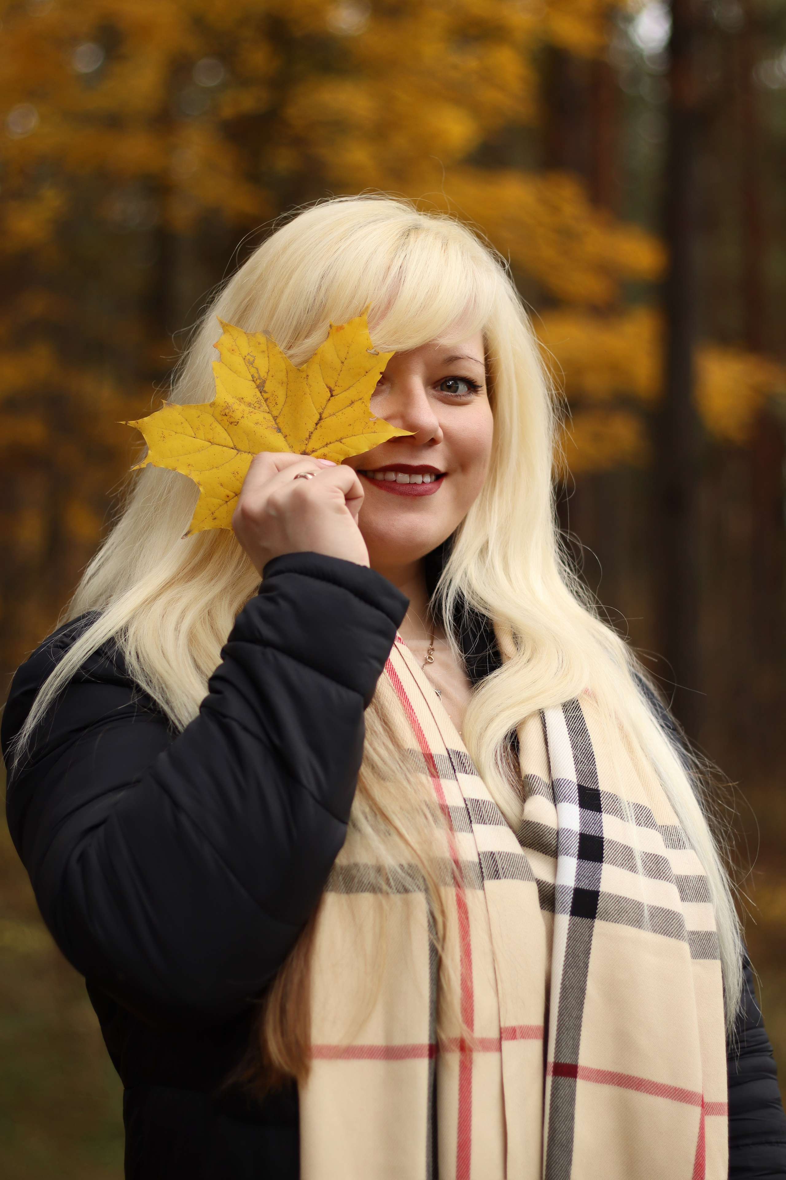 Rudens fotosesija Daugavpilī – sieviete ar dzeltenu kļavas lapu rudens parkā