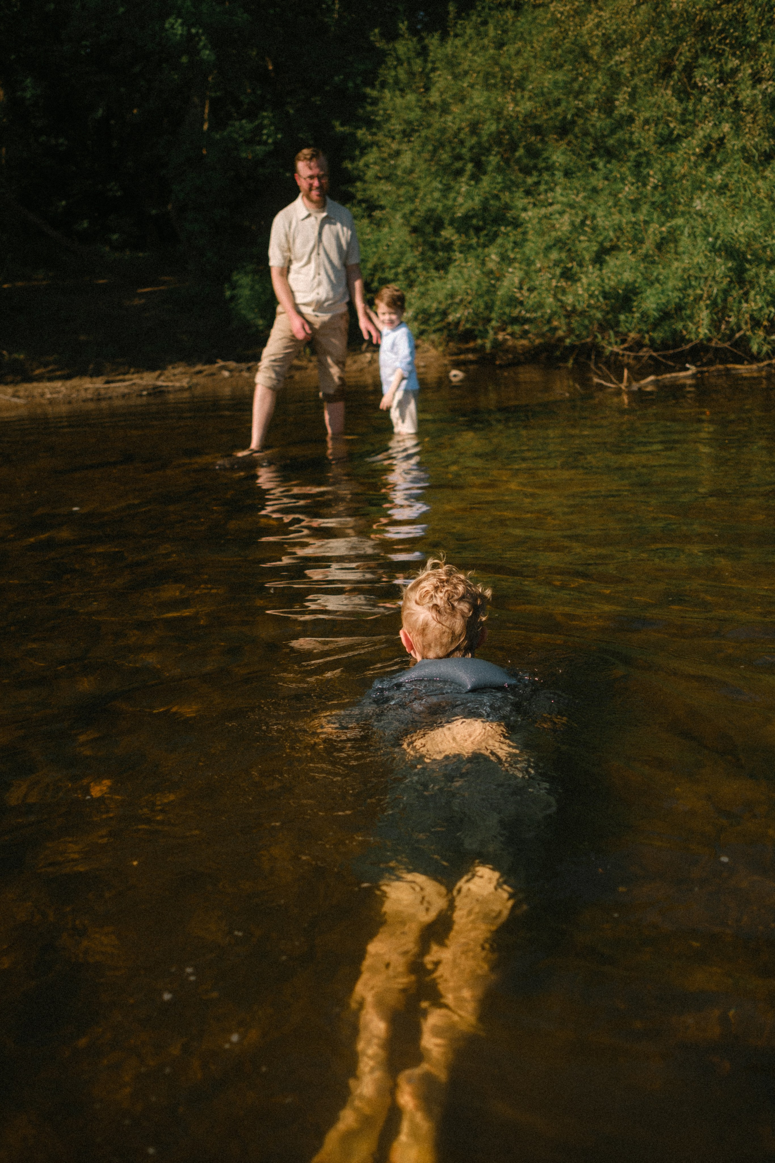 Beautiful, cinematic family portrait capturing a genuine, unposed moment on the river rocks in Richmond, VA