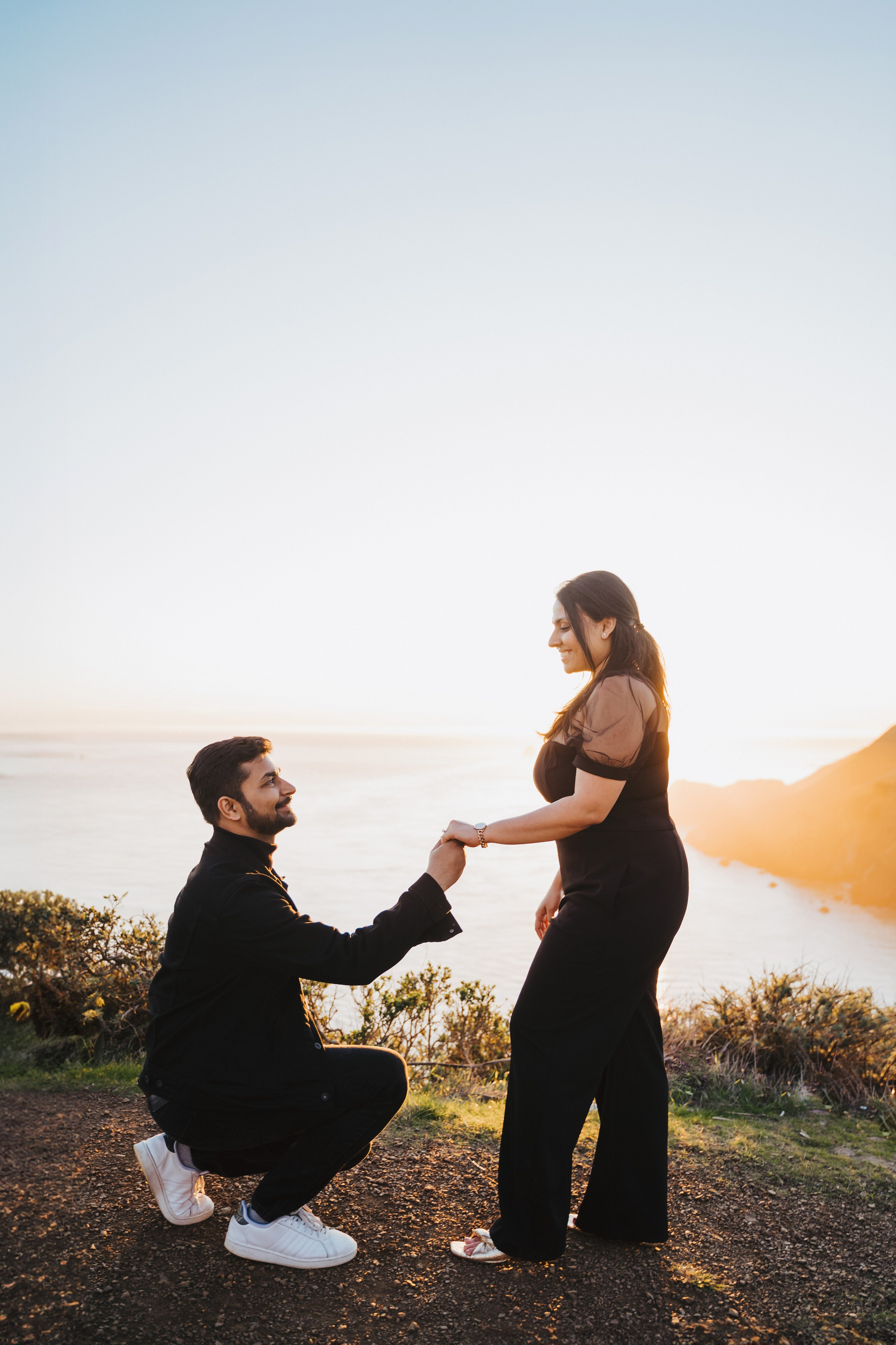 Proposal.  Overlooking the golden San Franisco Bridge sunset with a couple. Photographer Video. 