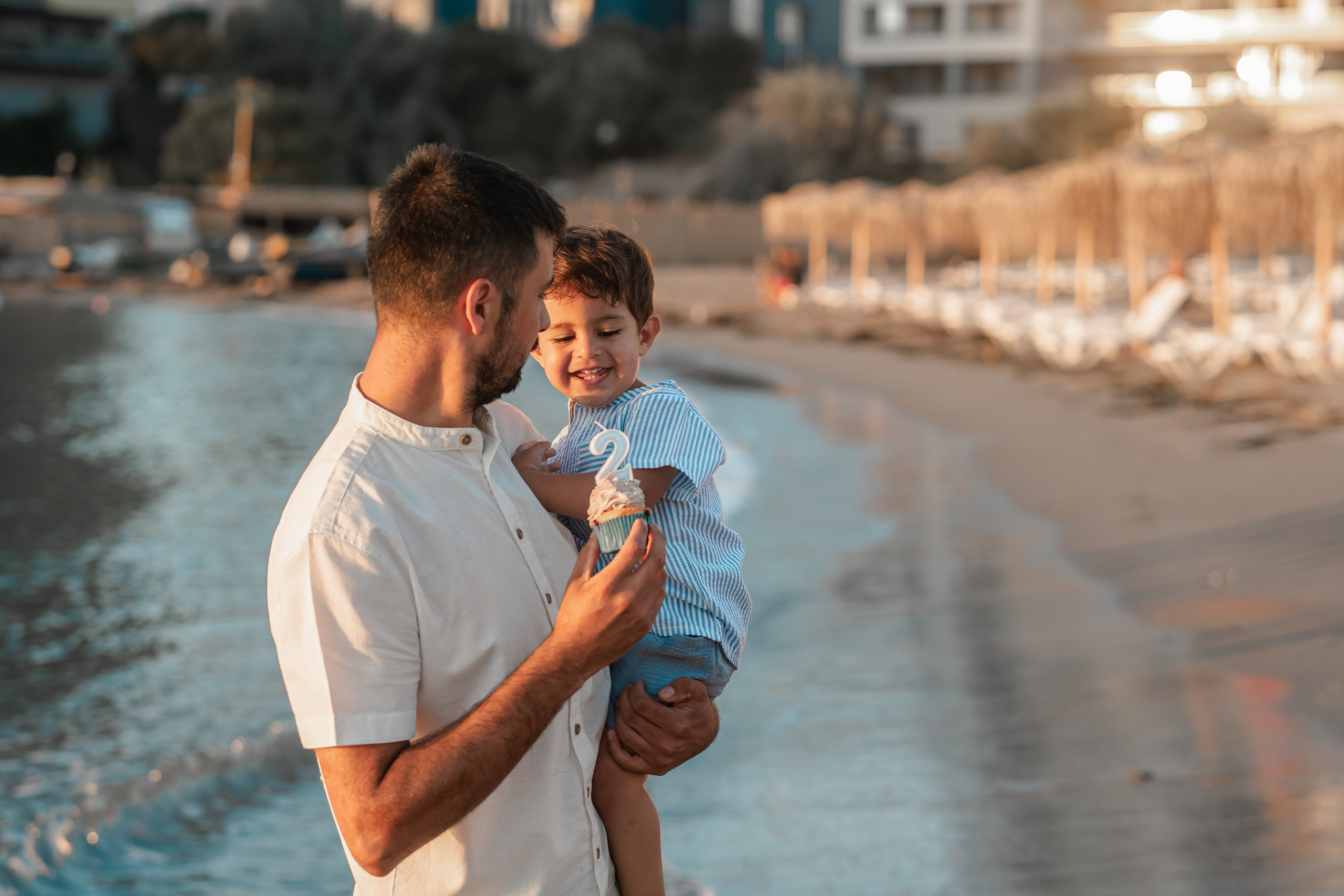 copil care rade in bratele tatalui