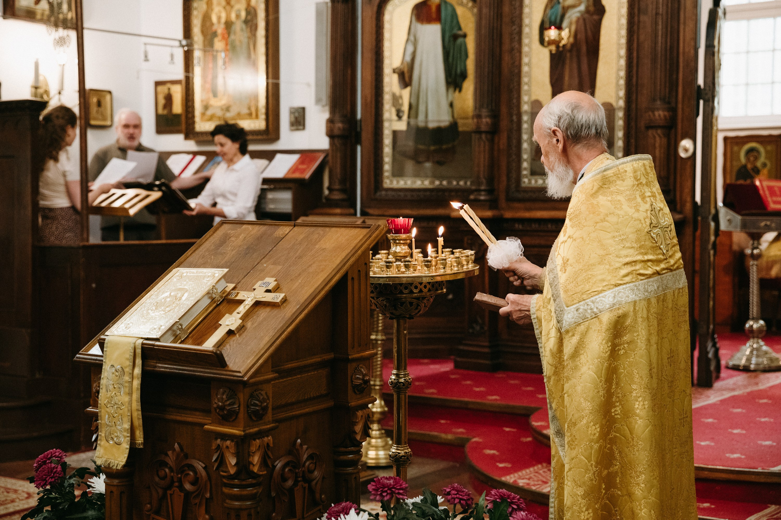 Priester zündet Kerzen am Altar während der orthodoxen Trauung an