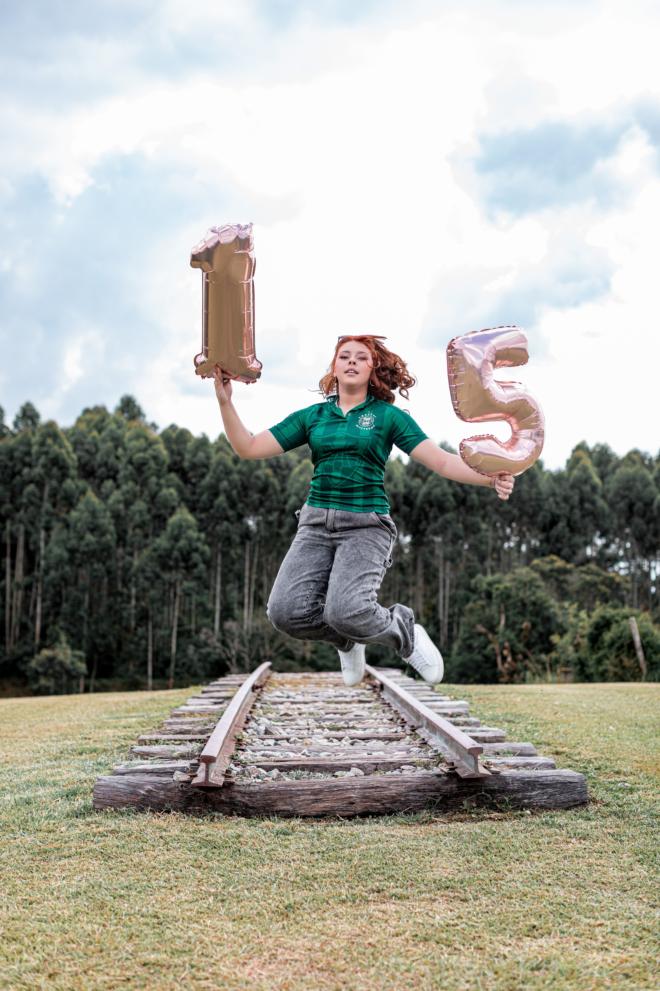 Moça pula de alegria com balões em seu ensaio debutante