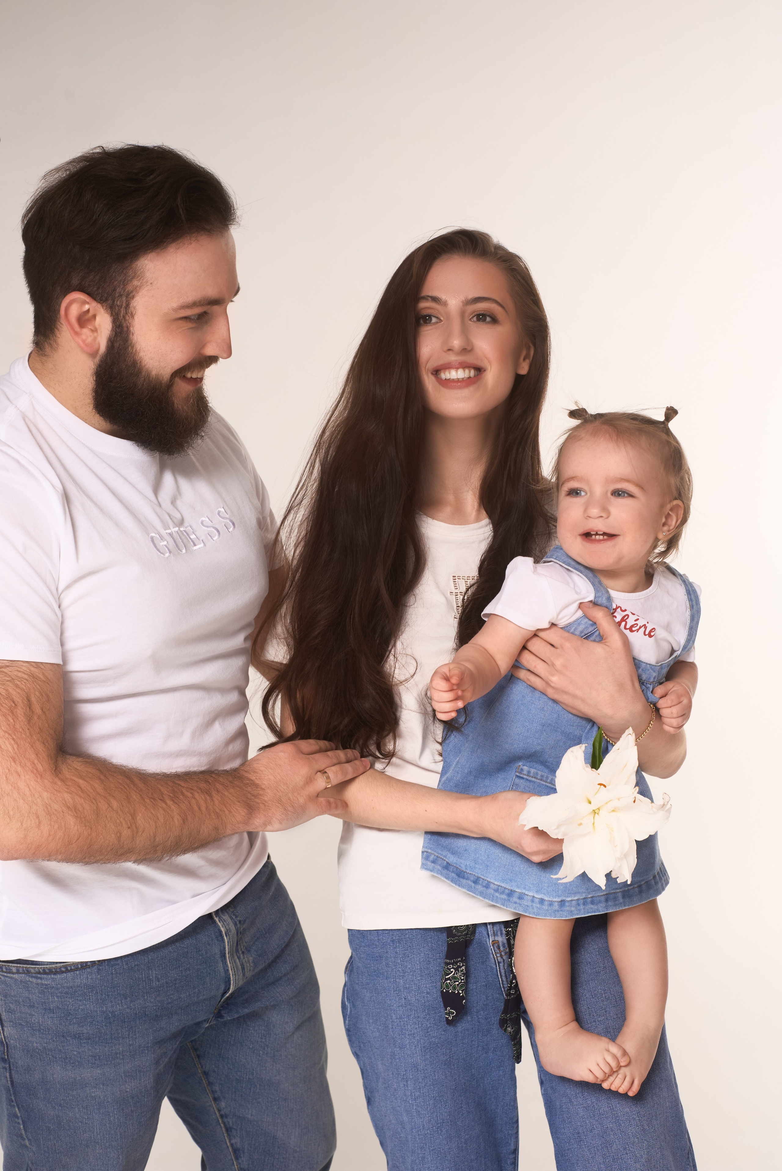 Profesjonalna rodzinna sesja zdjęciowa – szczęśliwi rodzice z małym dzieckiem w jasnej, ciepłej stylistyce