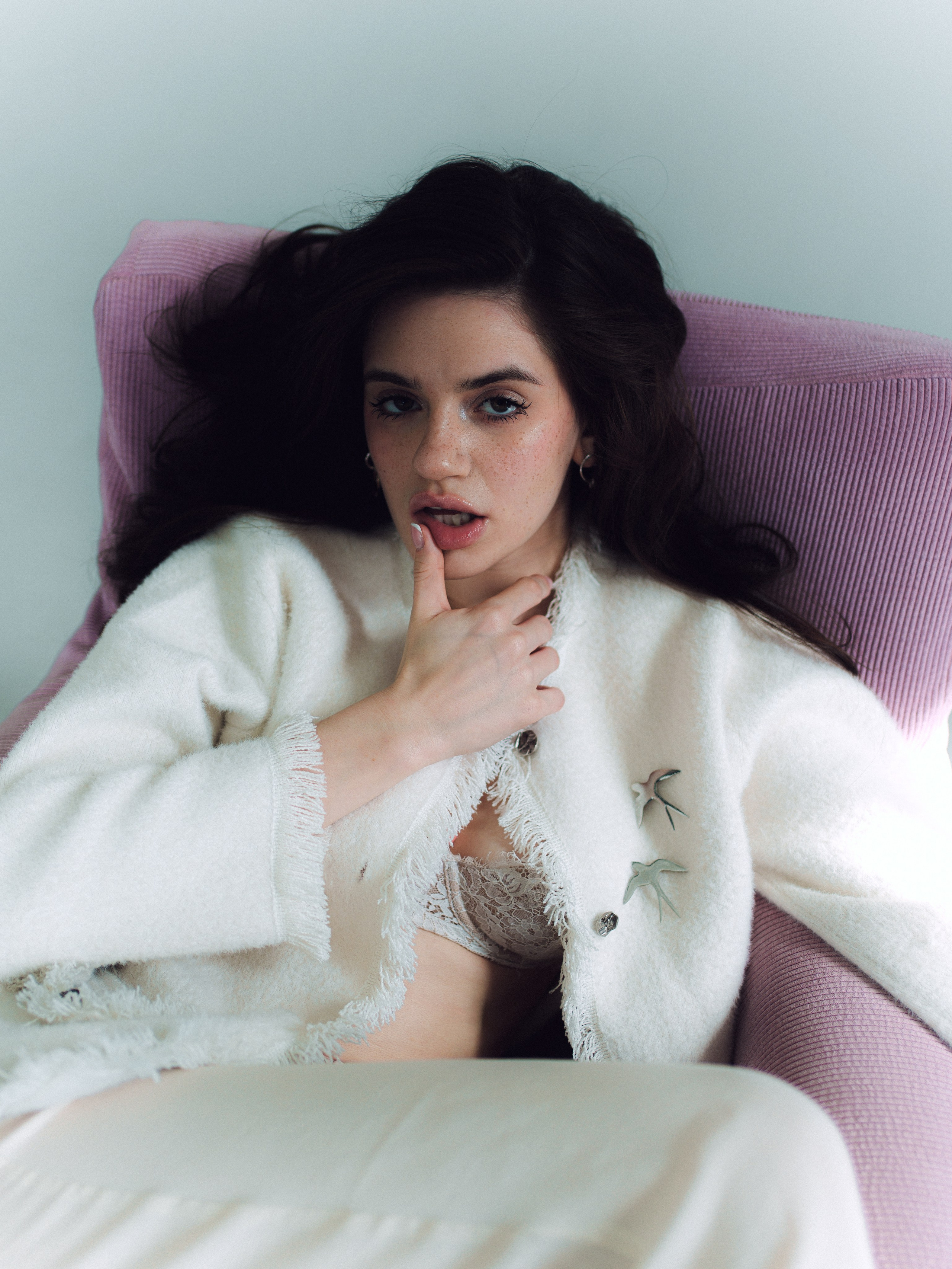 Close-up portrait of woman in white cardigan in gentle light
