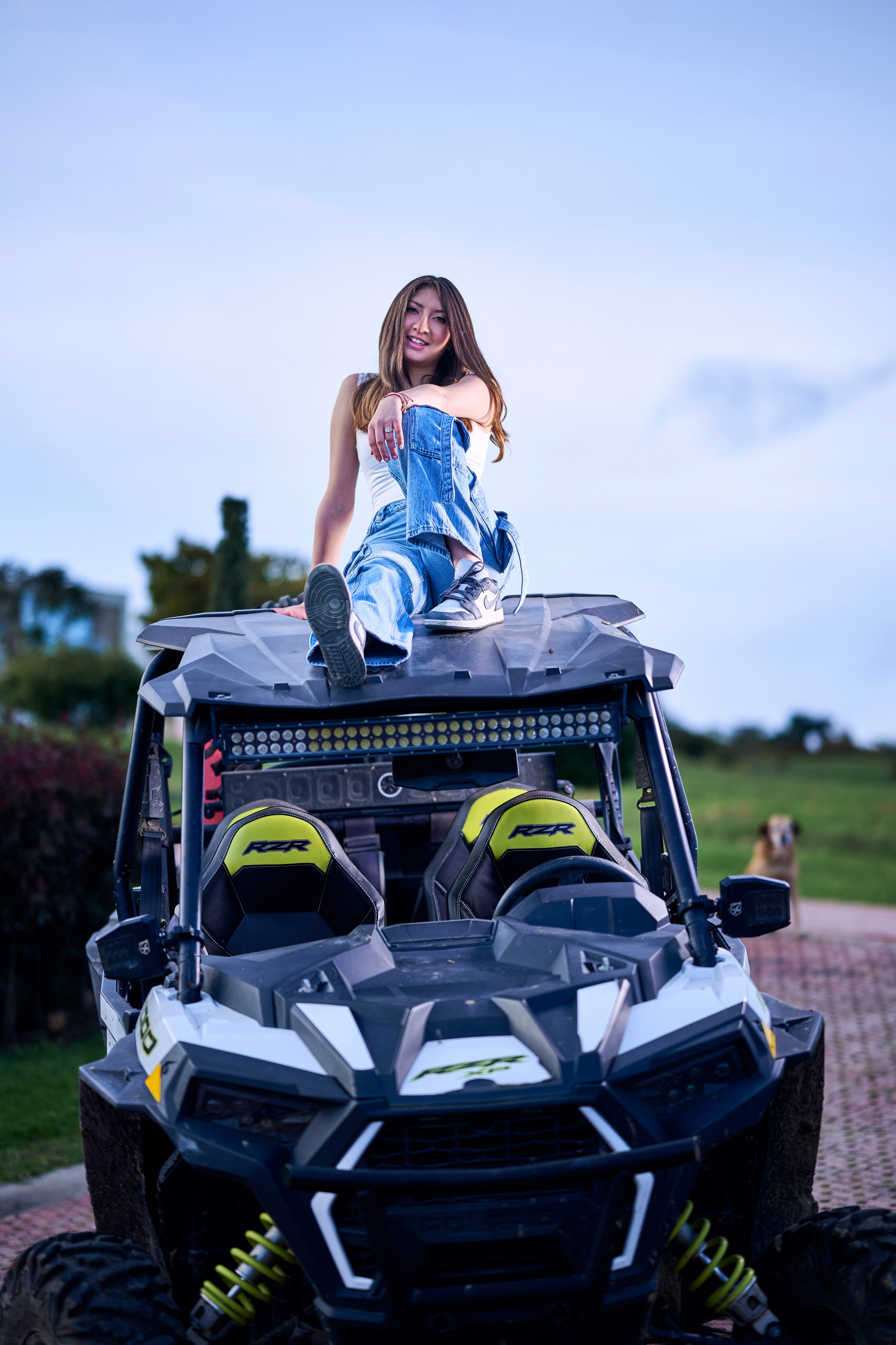 Valentina luciendo un look juvenil y rebelde junto a un carro buggy de colección.