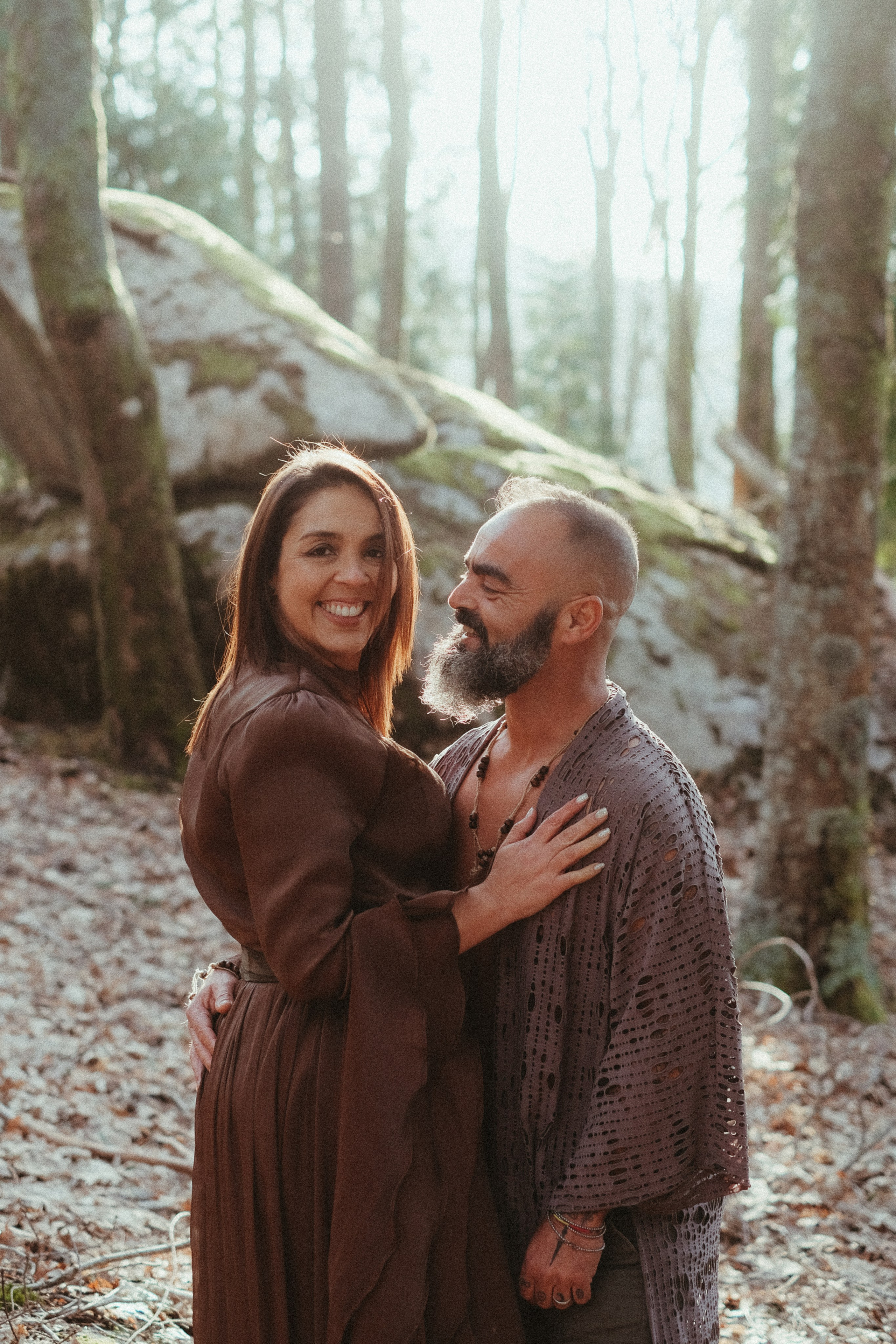 Couple on mossy rock during forest engagement session in Portugal