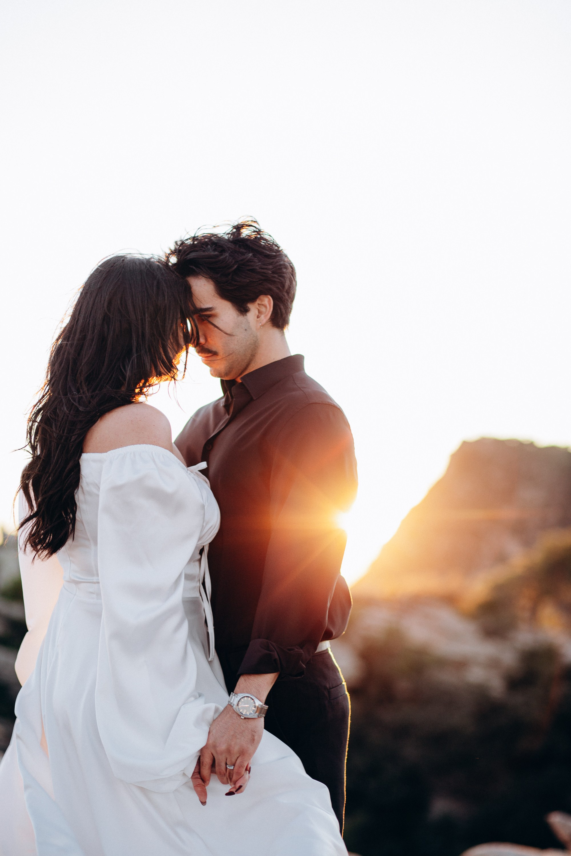 Bride and groom sharing a quiet sunset moment on mountain rocks during their intimate destination wedding in Barcelona, Spain. Warm backlight adds emotion and depth to this romantic elopement portrait.