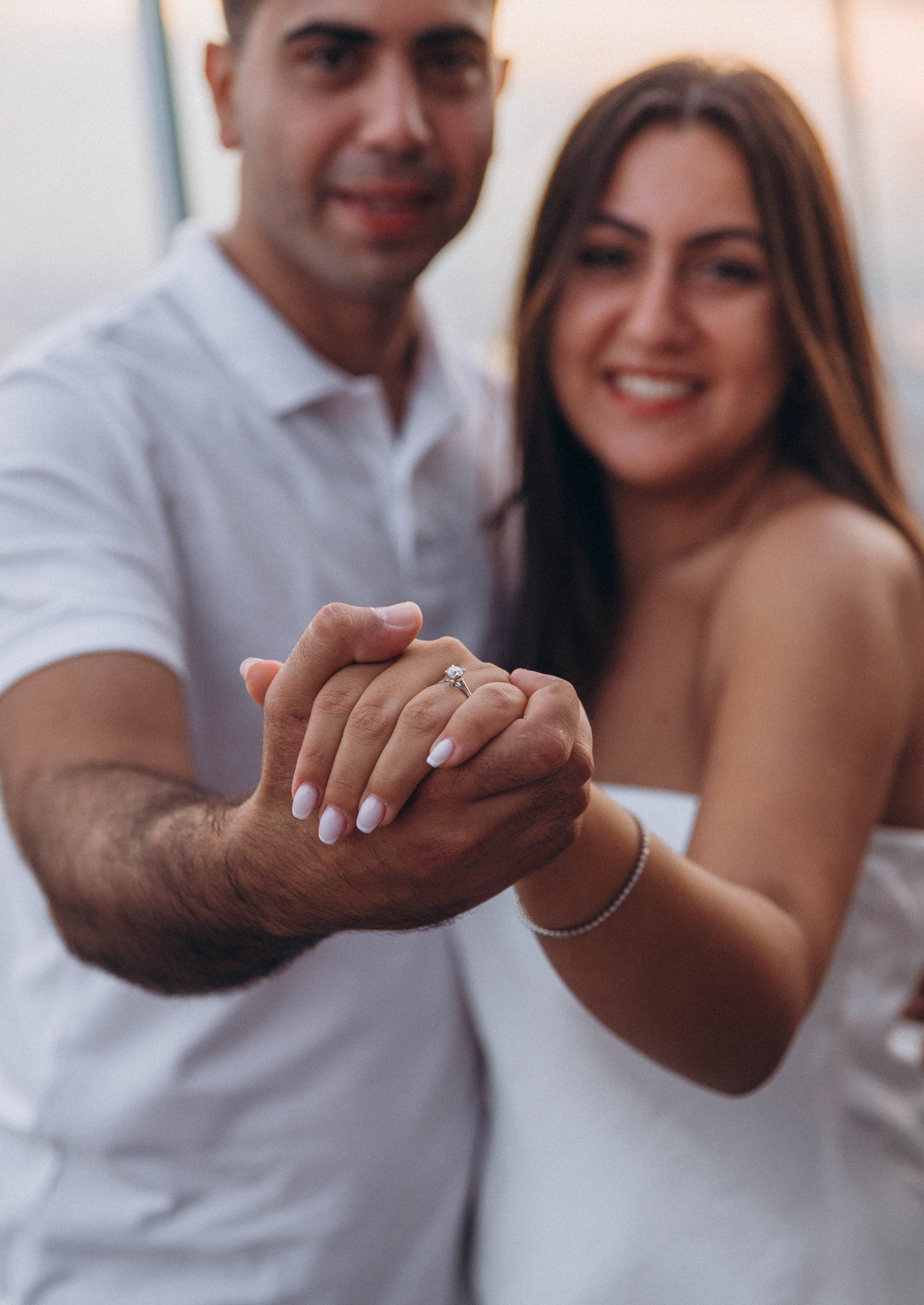 Couple celebrating engagement with Brooklyn skyline view.
