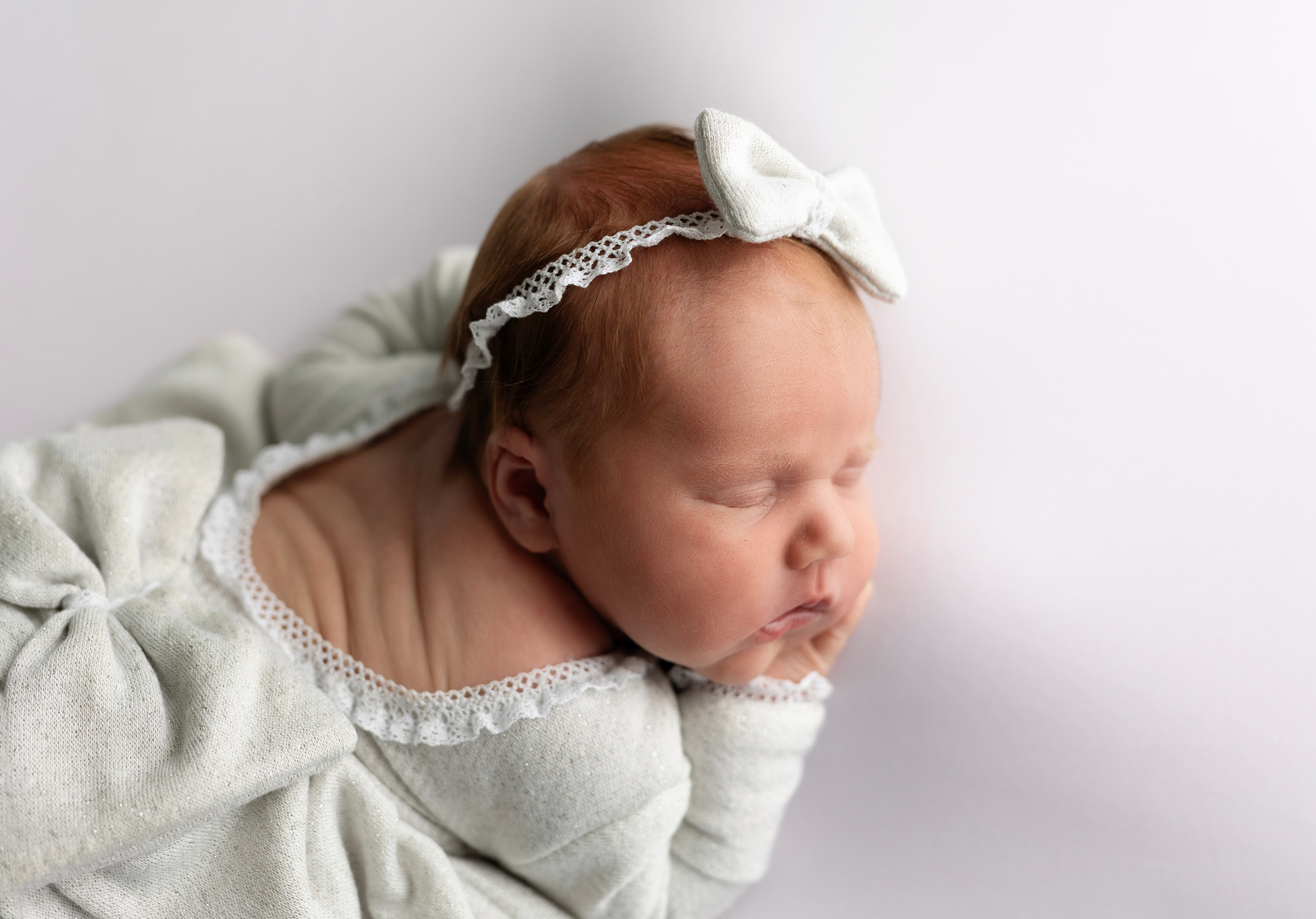 Een klein kindje ligt rustig in een bedje.