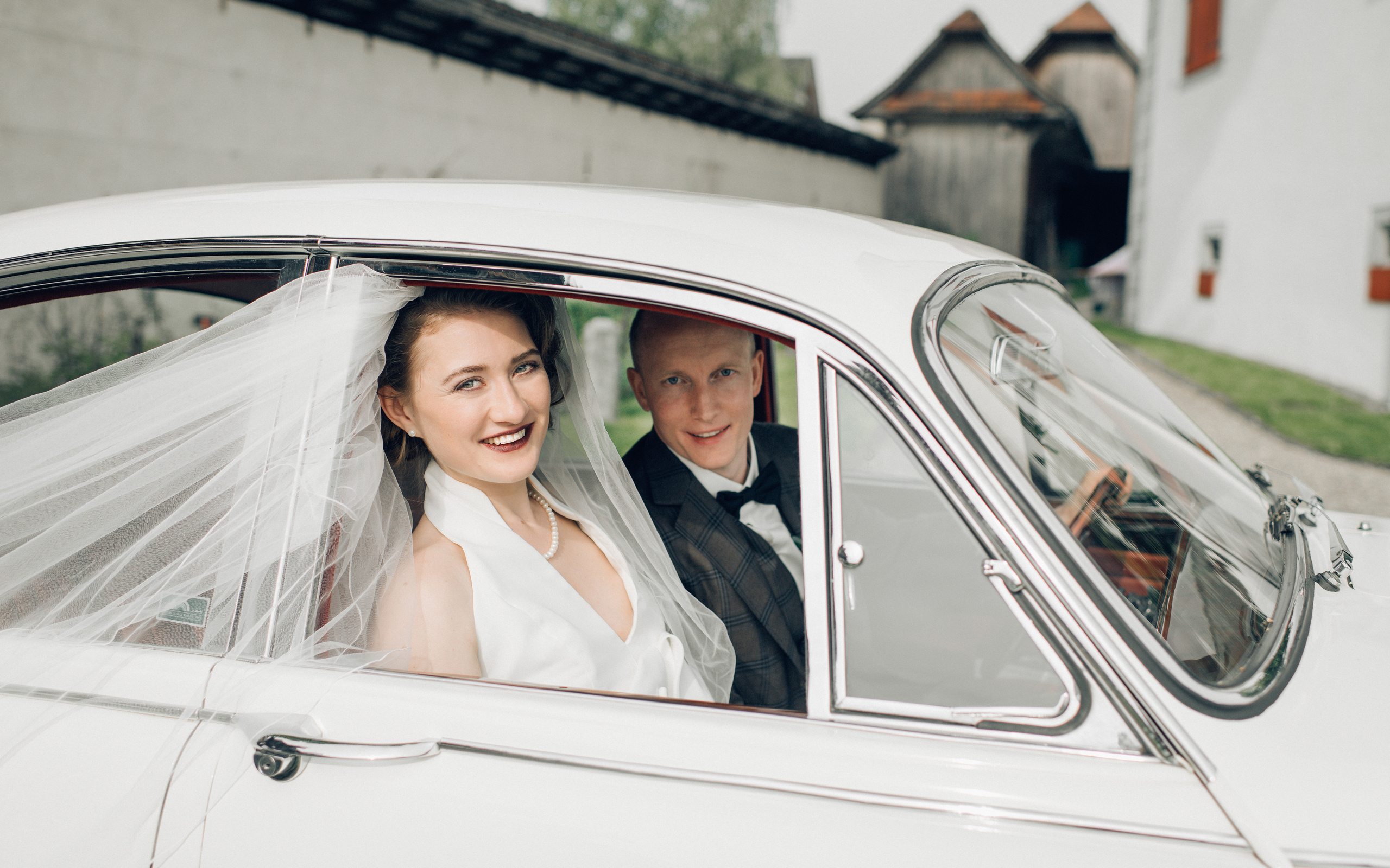 A wedding couple on a wedding day go with an old timer to the wedding ceremony