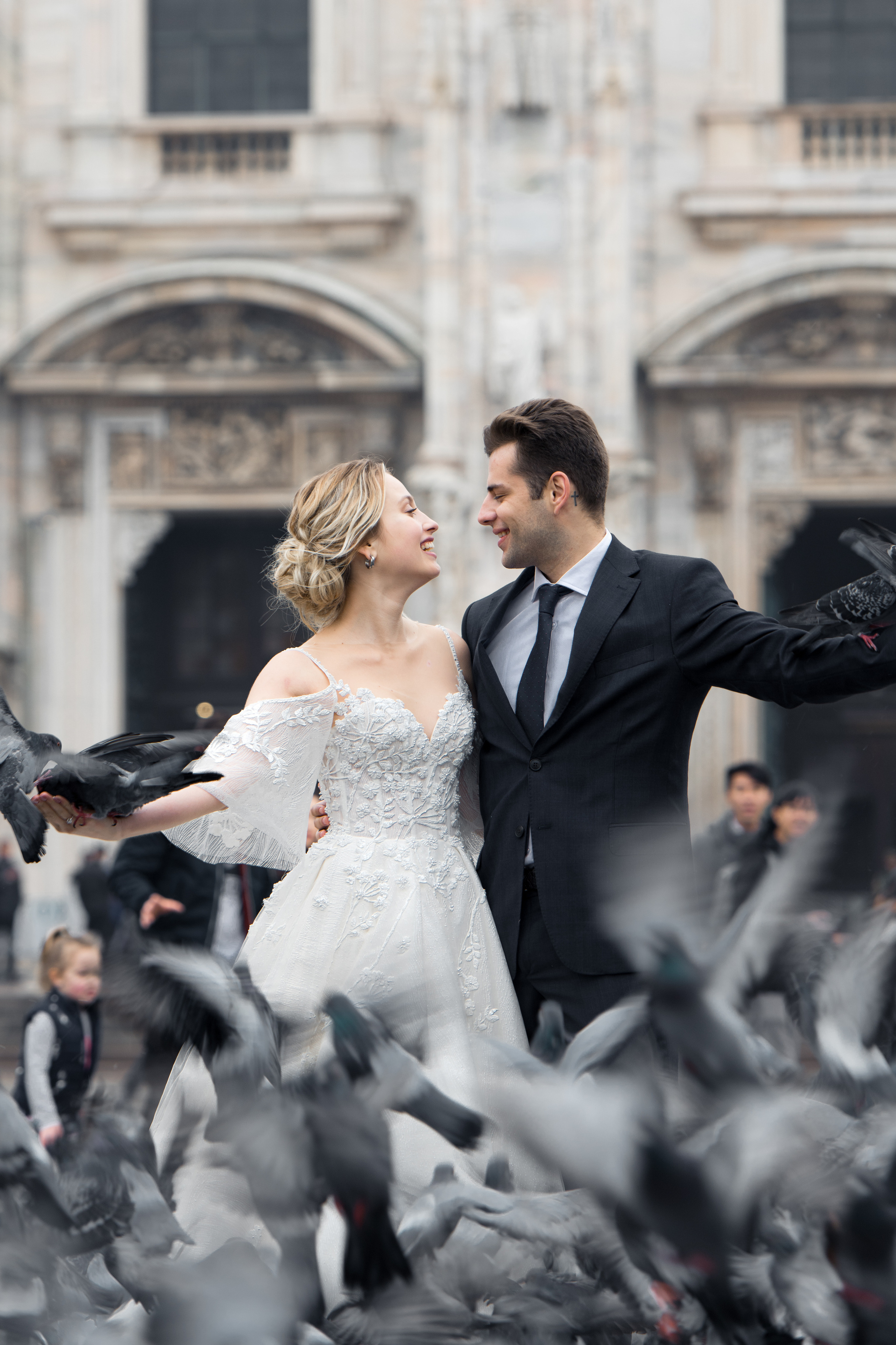 A beautiful wedding couple in Milan, Italy near Milan Cathedral with flying doves. Milano Duomo wedding