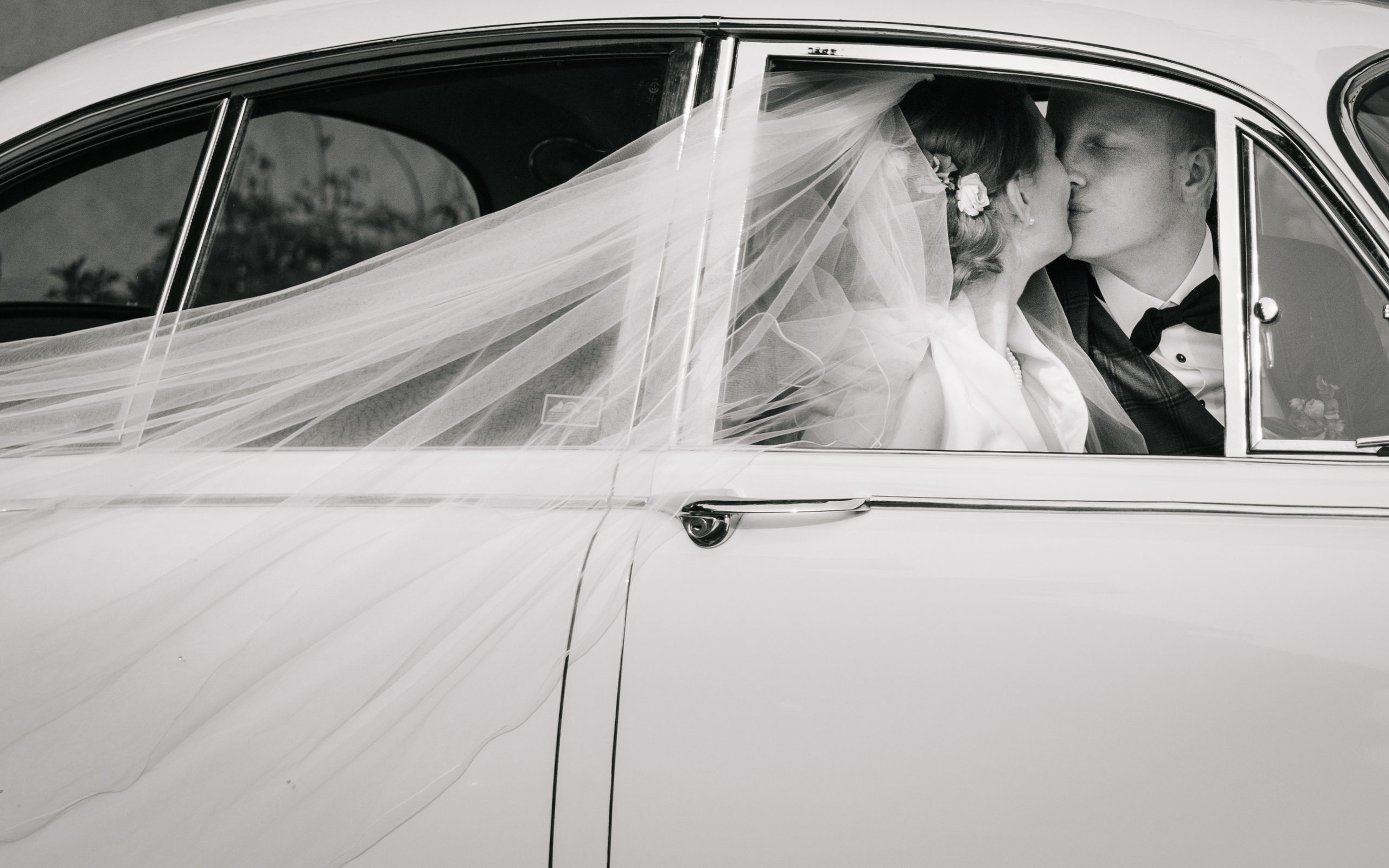 A wedding couple on a wedding day go with an old timer to the wedding ceremony