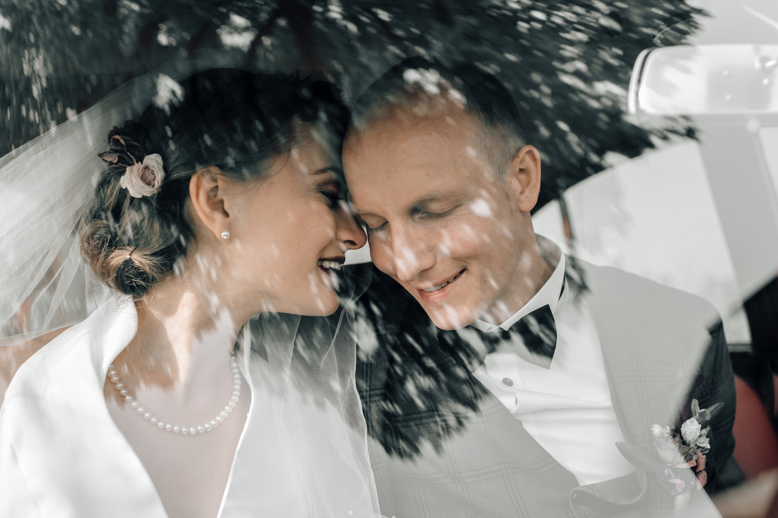 A wedding couple cuddling in an old timer on a wedding day