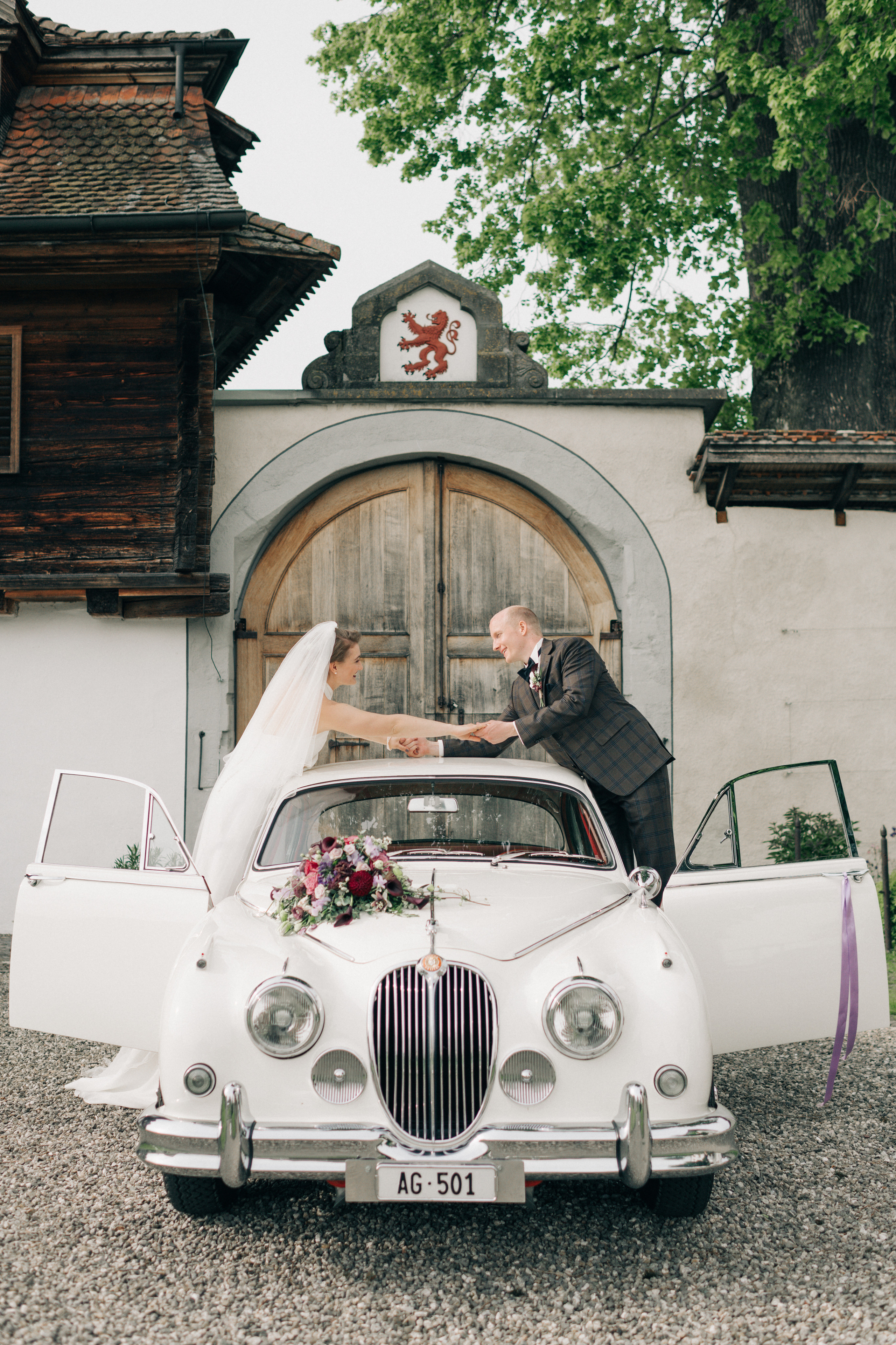 A wedding couple on a wedding day go with an old timer to the wedding ceremony
