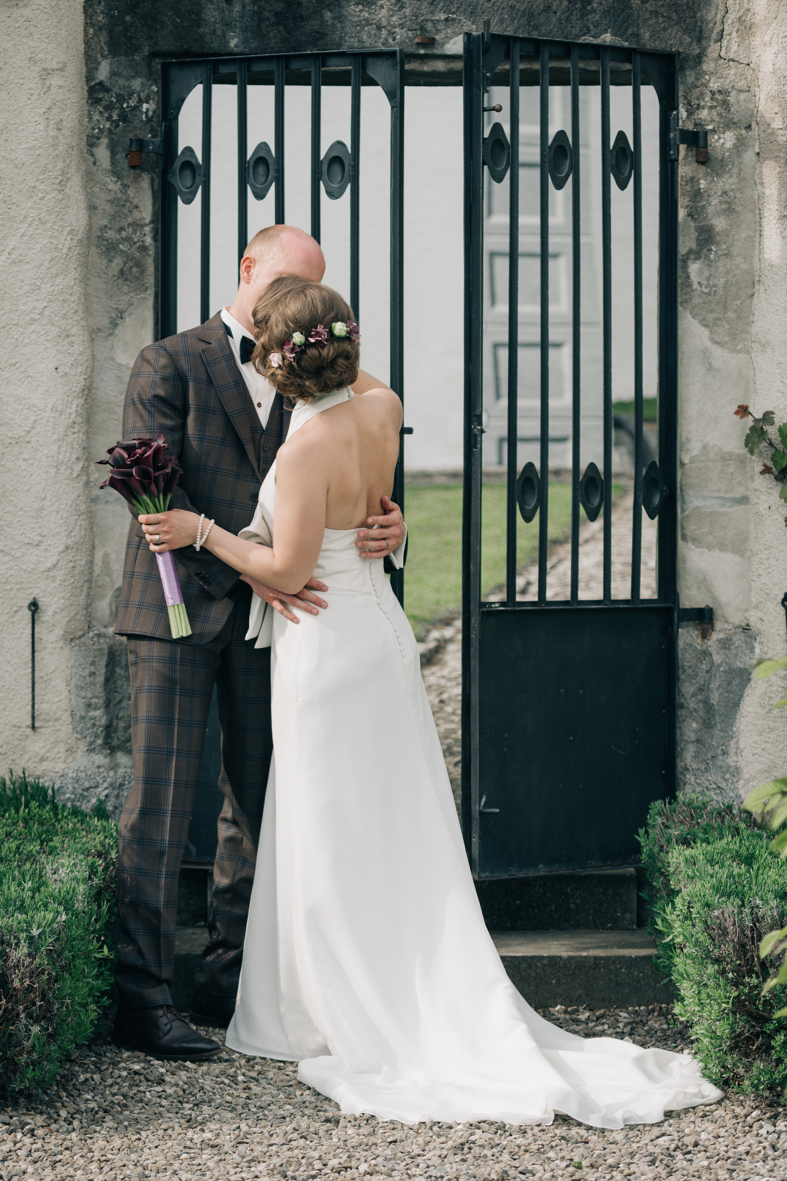 A wedding couple kissing in a park