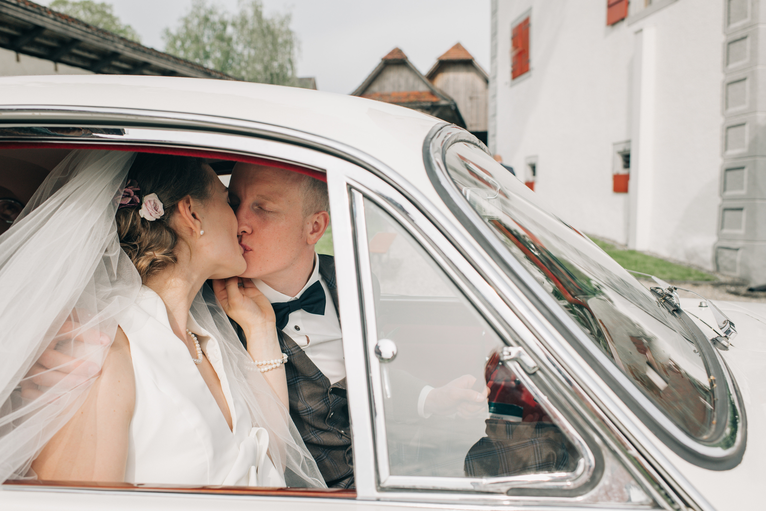 A wedding couple on a wedding day go with an old timer to the wedding ceremony