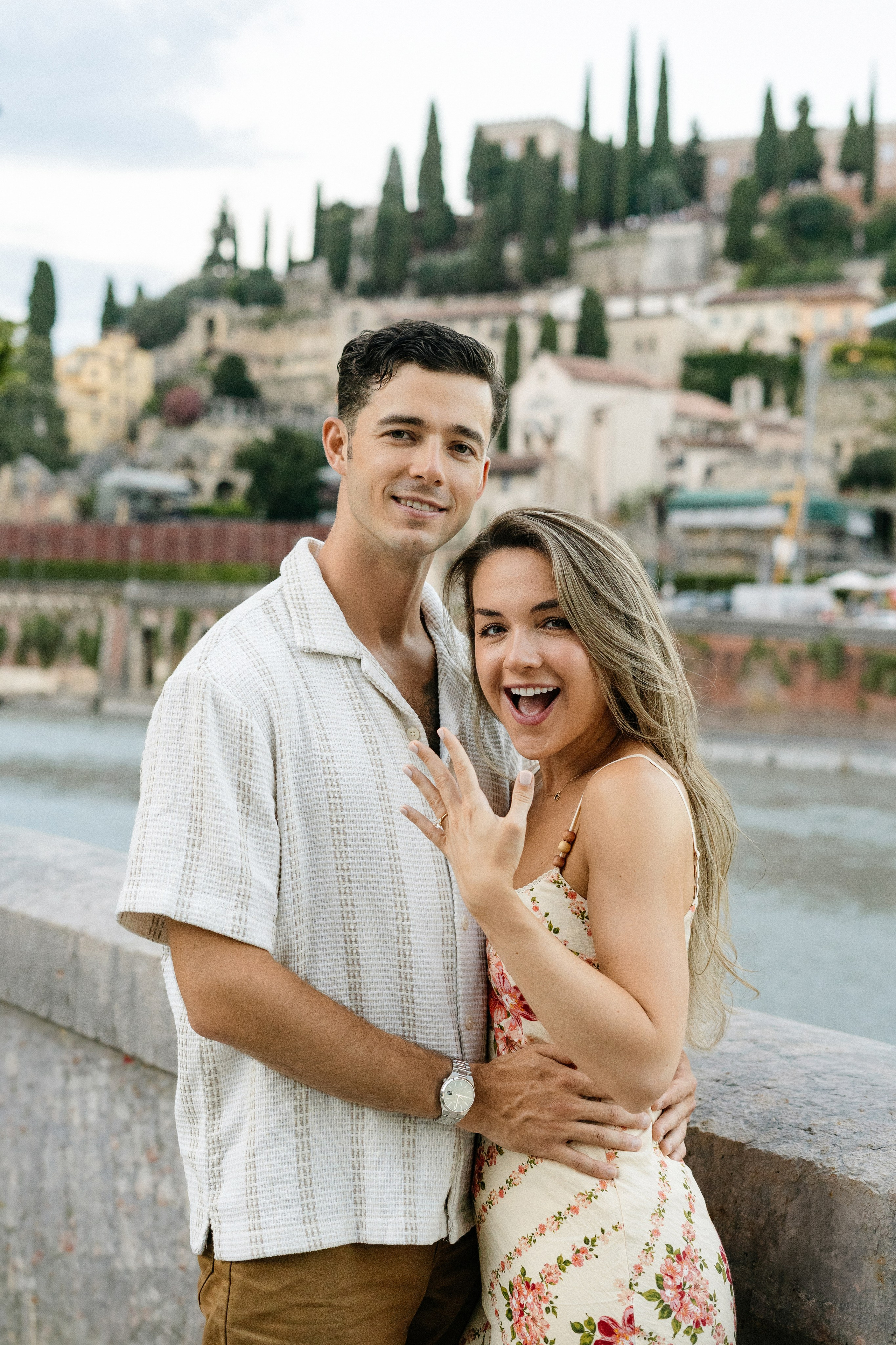 Couple embracing in the charming streets of Verona after a surprise proposal