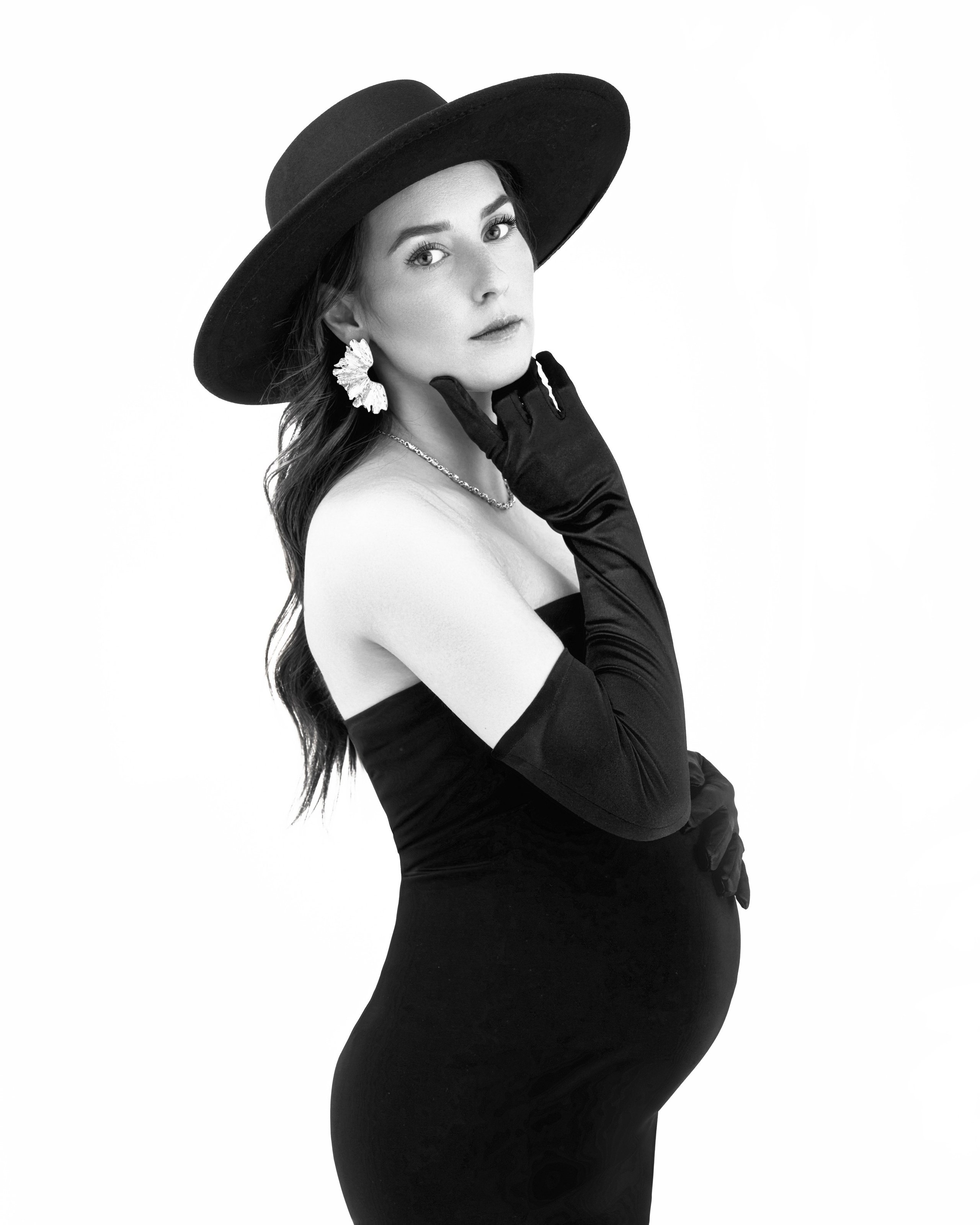 Salt Lake City maternity photography, black and white studio portrait of pregnant woman in black dress and wide-brim hat at Shtatolkina Studio