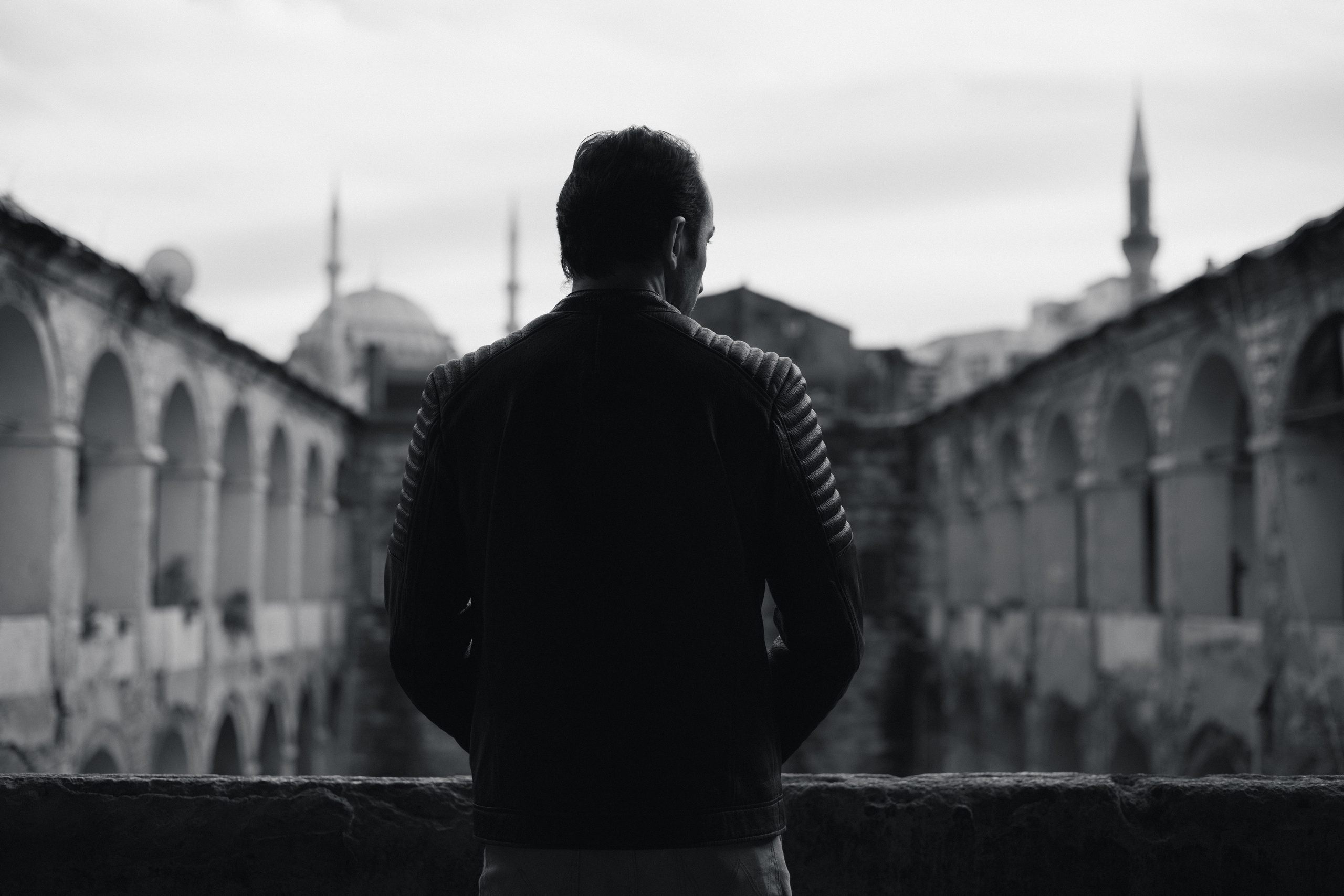 Портрет мужчины со спины у каменного парапета в исторической аркаде Стамбула