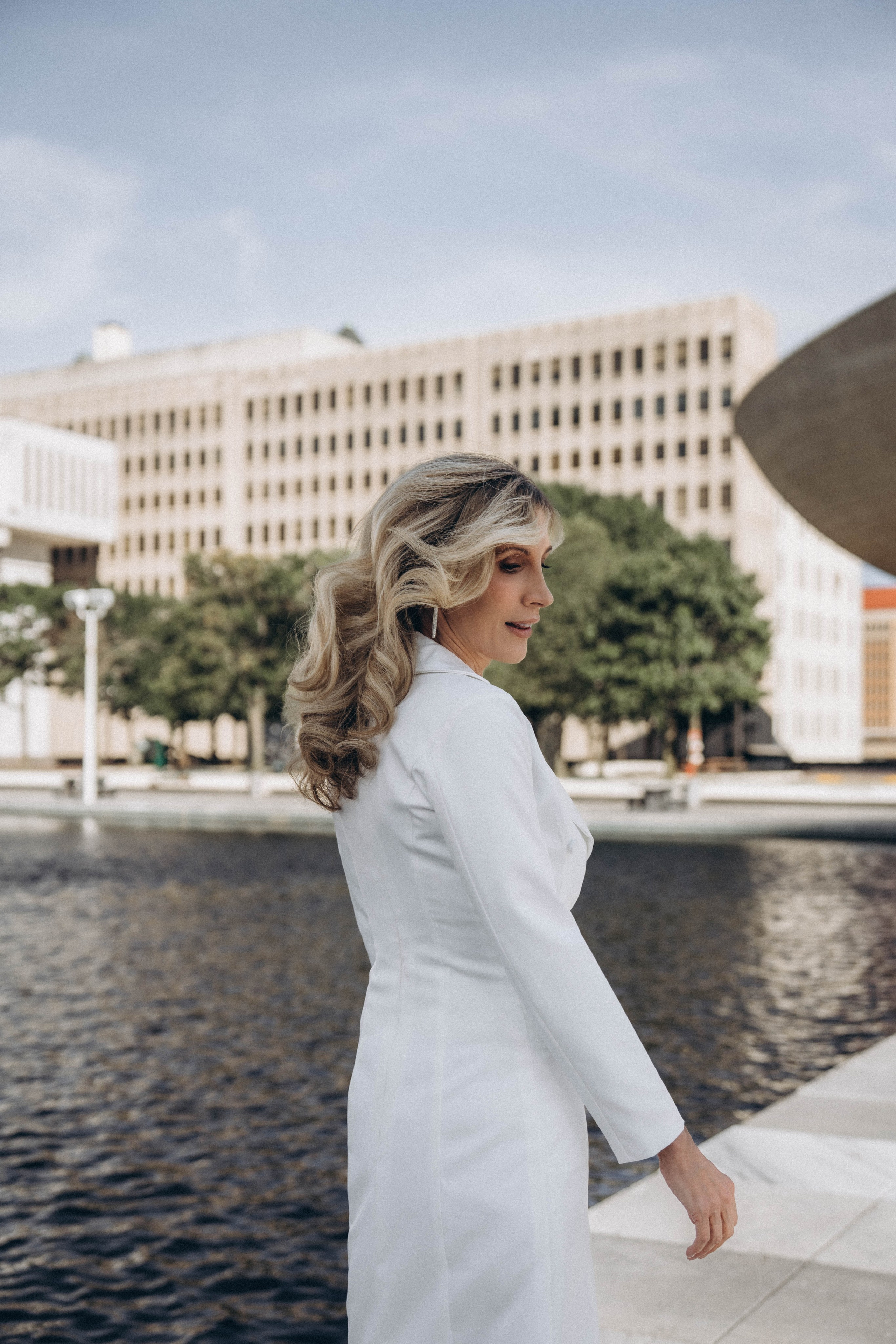 Bride standing by Adirondack forest with soft sunlight.