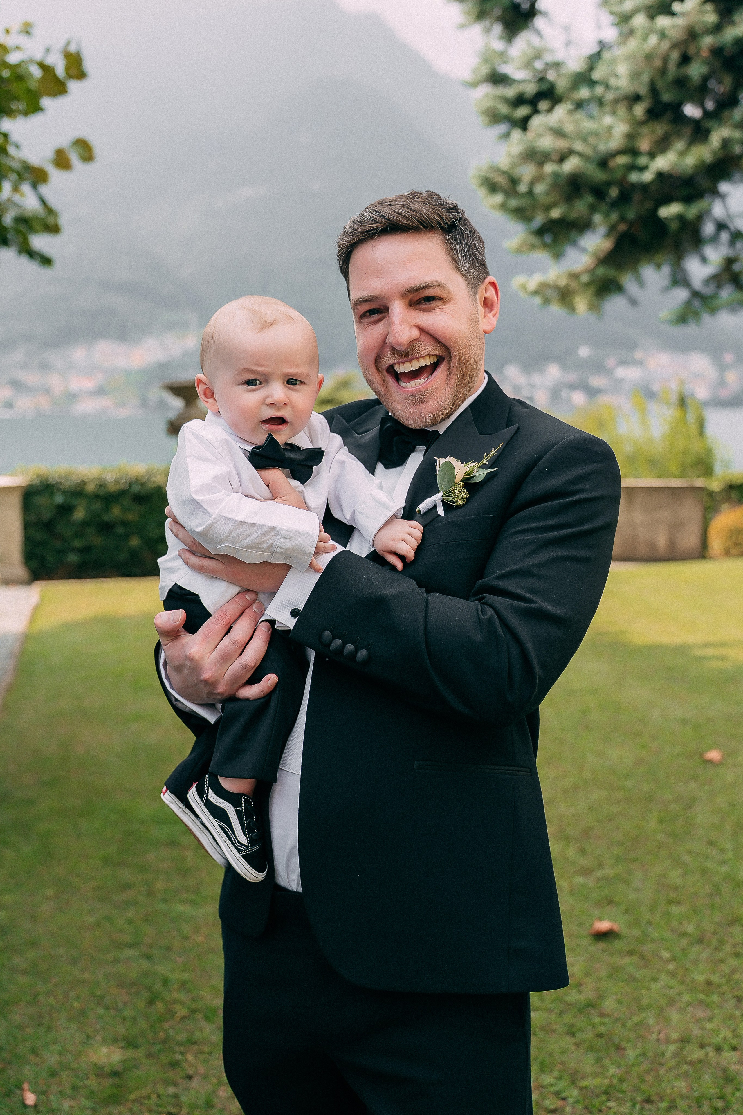 Groom smiling with a baby at Villa Lario, Lake Como, Italy