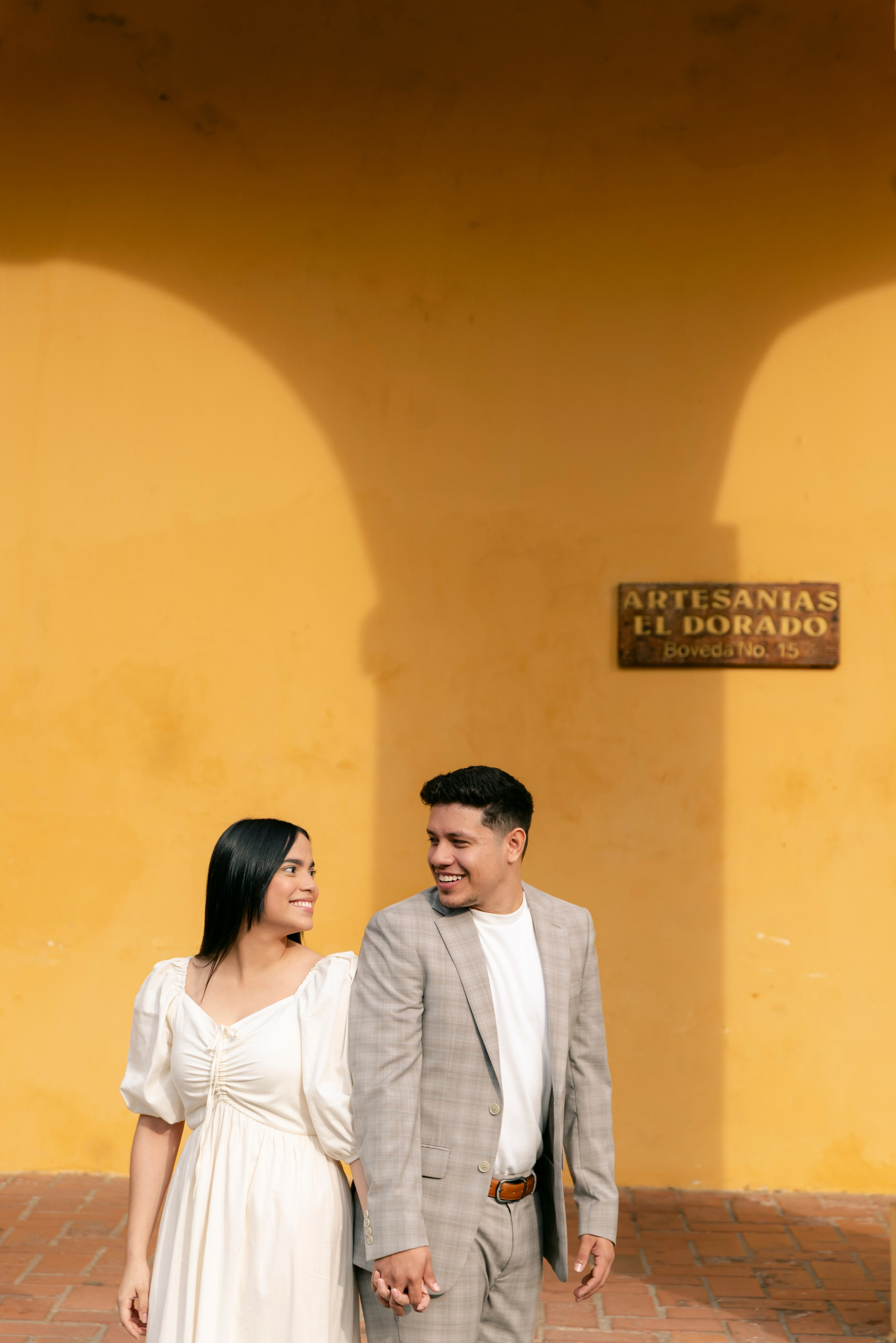 Novios posando en arquitectura colonial de Cartagena, estilo cinematográfico romántico