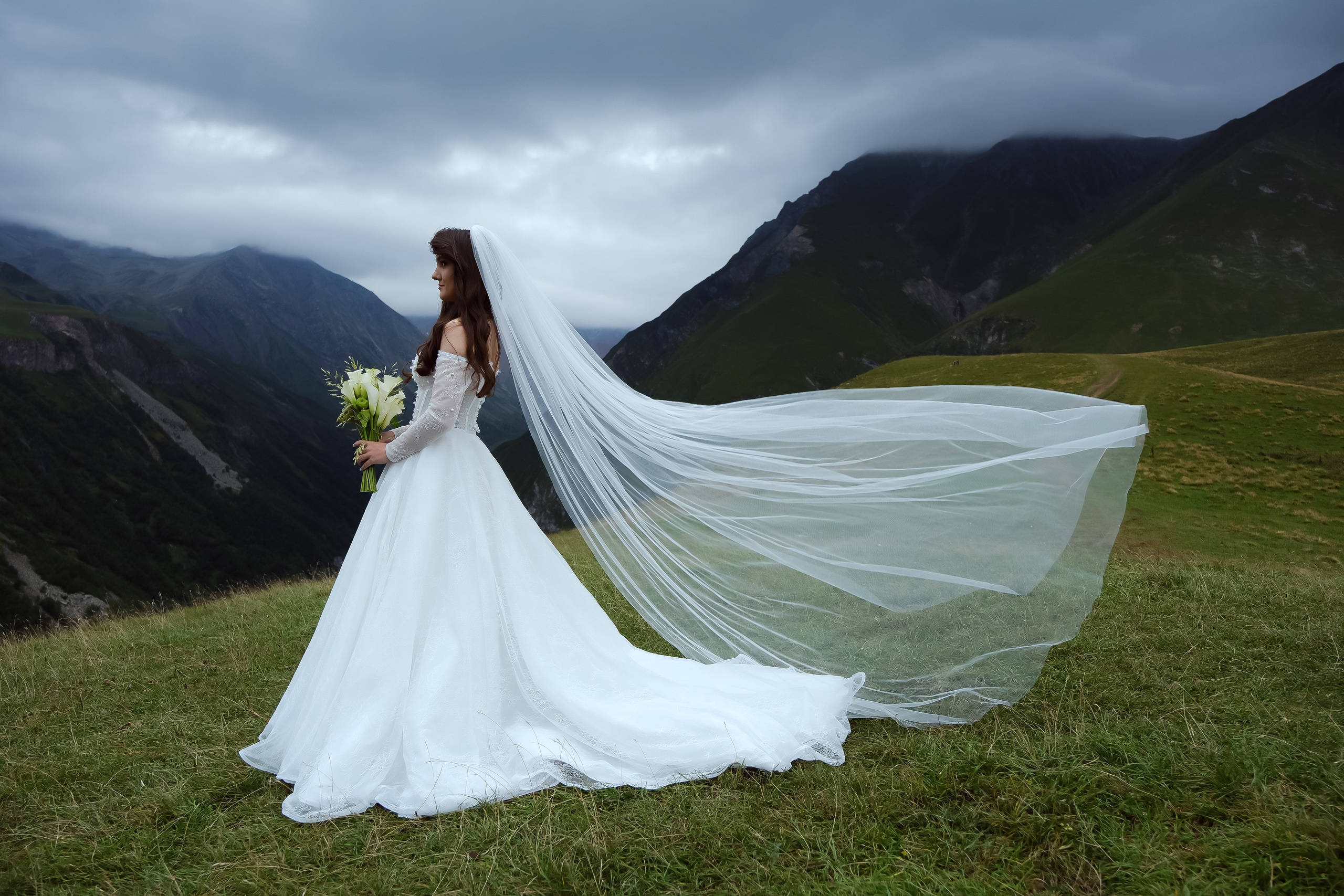 Bride with long veil in mountain wind