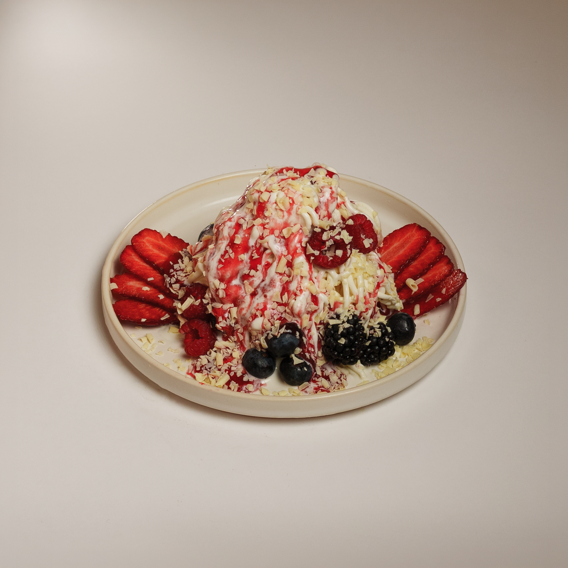 Fotografia de sobremesa artesanal em prato decorado com frutos vermelhos e chantilly, captada em estúdio pela Khave Media