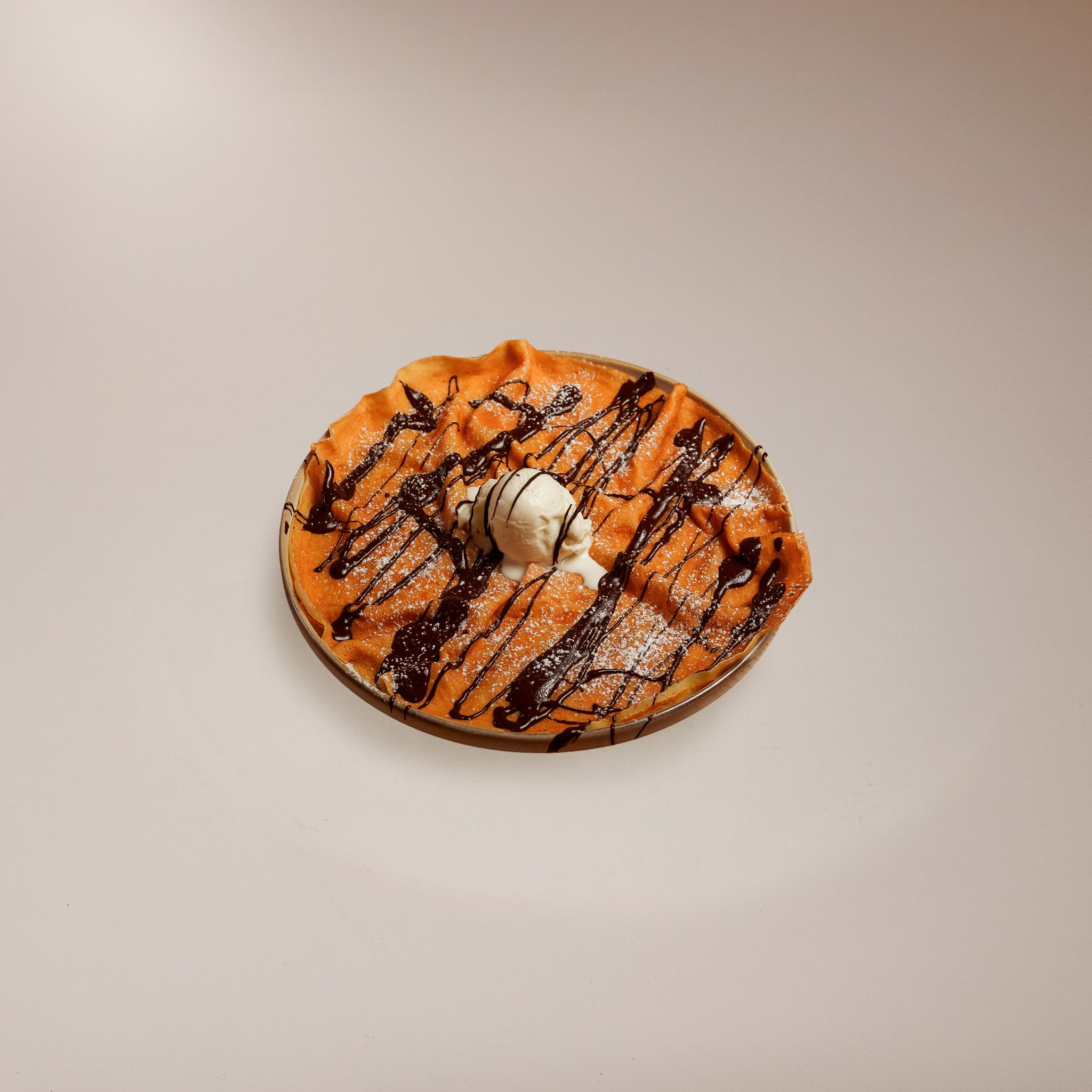 Fotografia de comida de uma sobremesa com gelado e calda de chocolate num fundo minimalista neutro