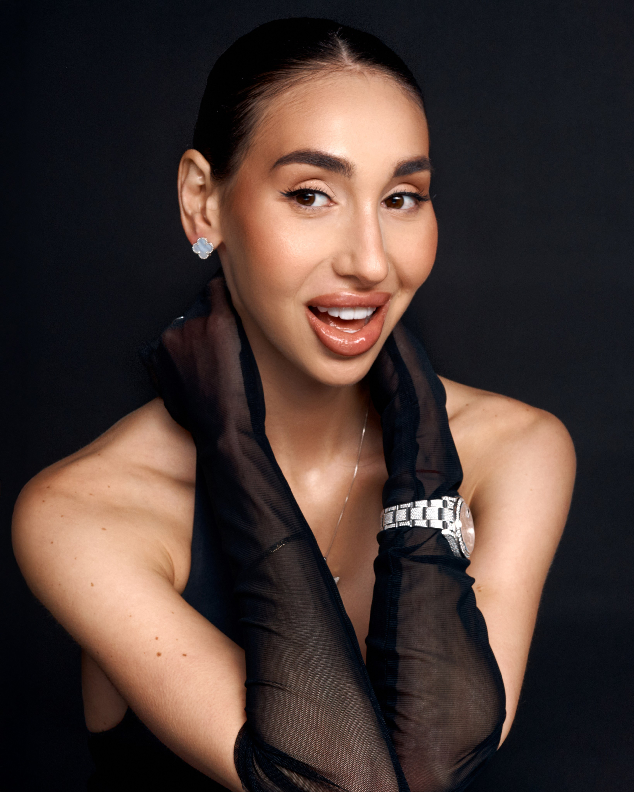 A minimalist studio portrait on a black background, expressing quiet confidence, refined elegance and a timeless personal presence.