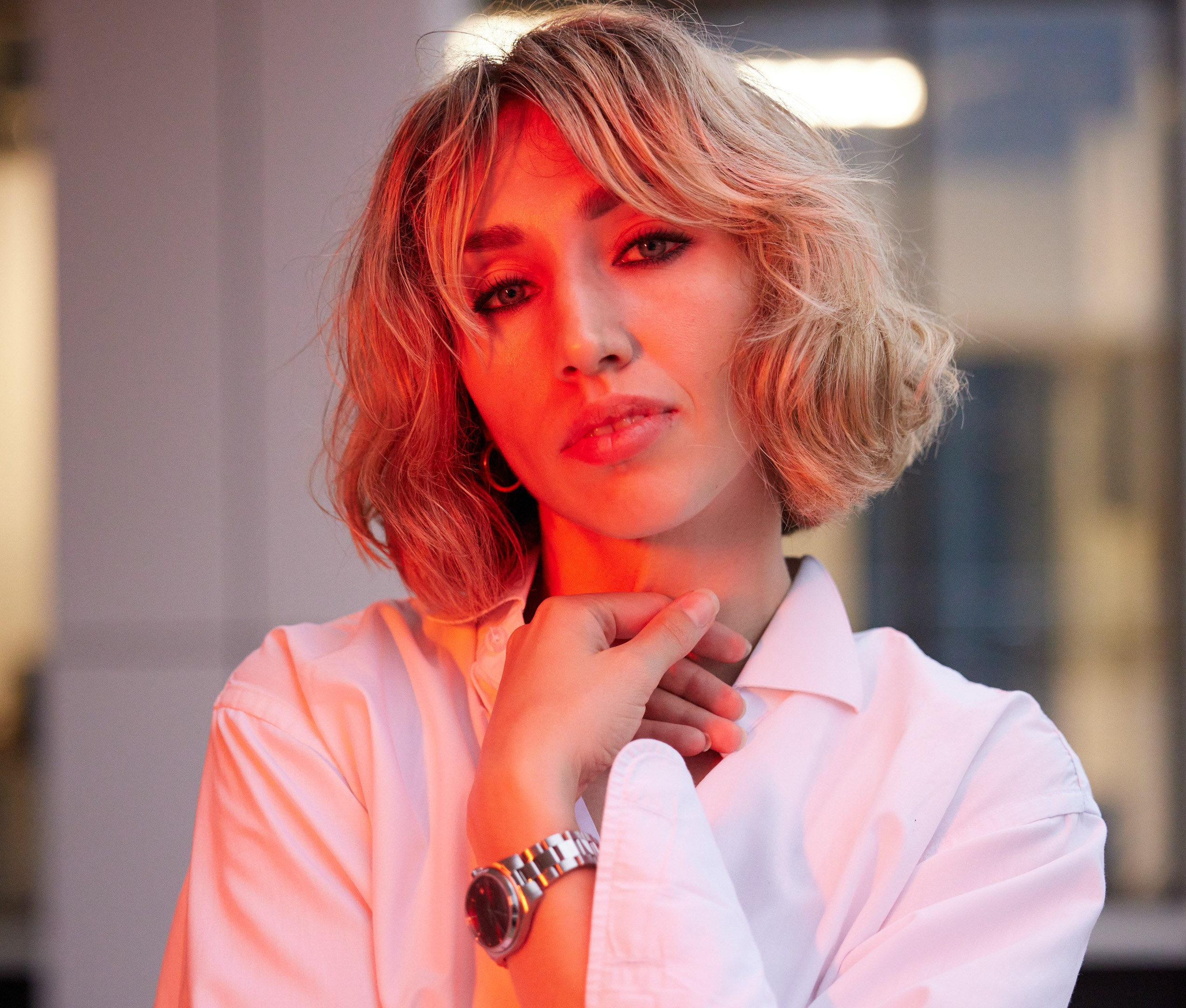 Location portrait of a young woman in red lighting against the backdrop of a building - photographer Andrey Dunin