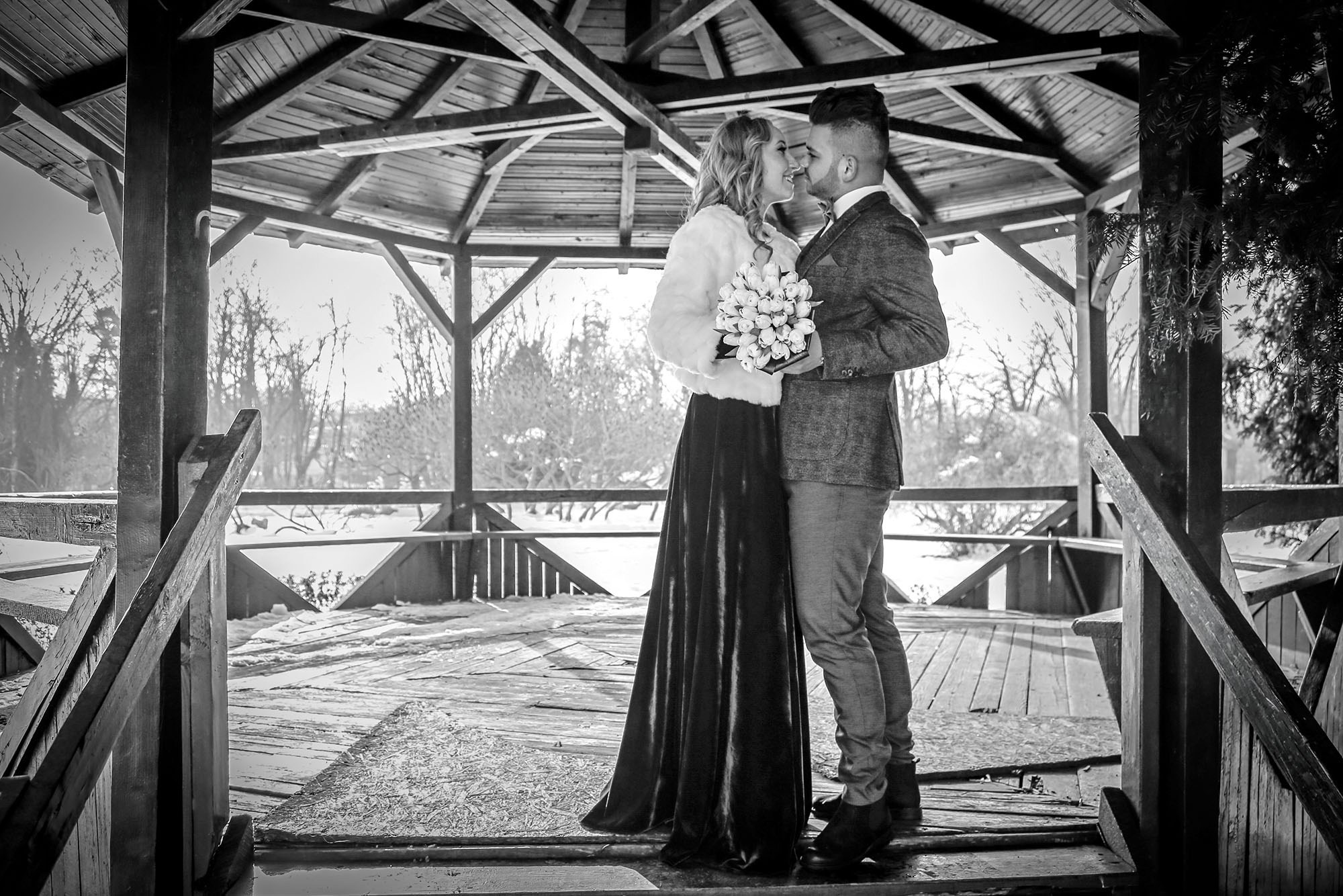 Artistic black and white photograph of the newlyweds embracing inside the gazebo, capturing a timeless emotional moment.