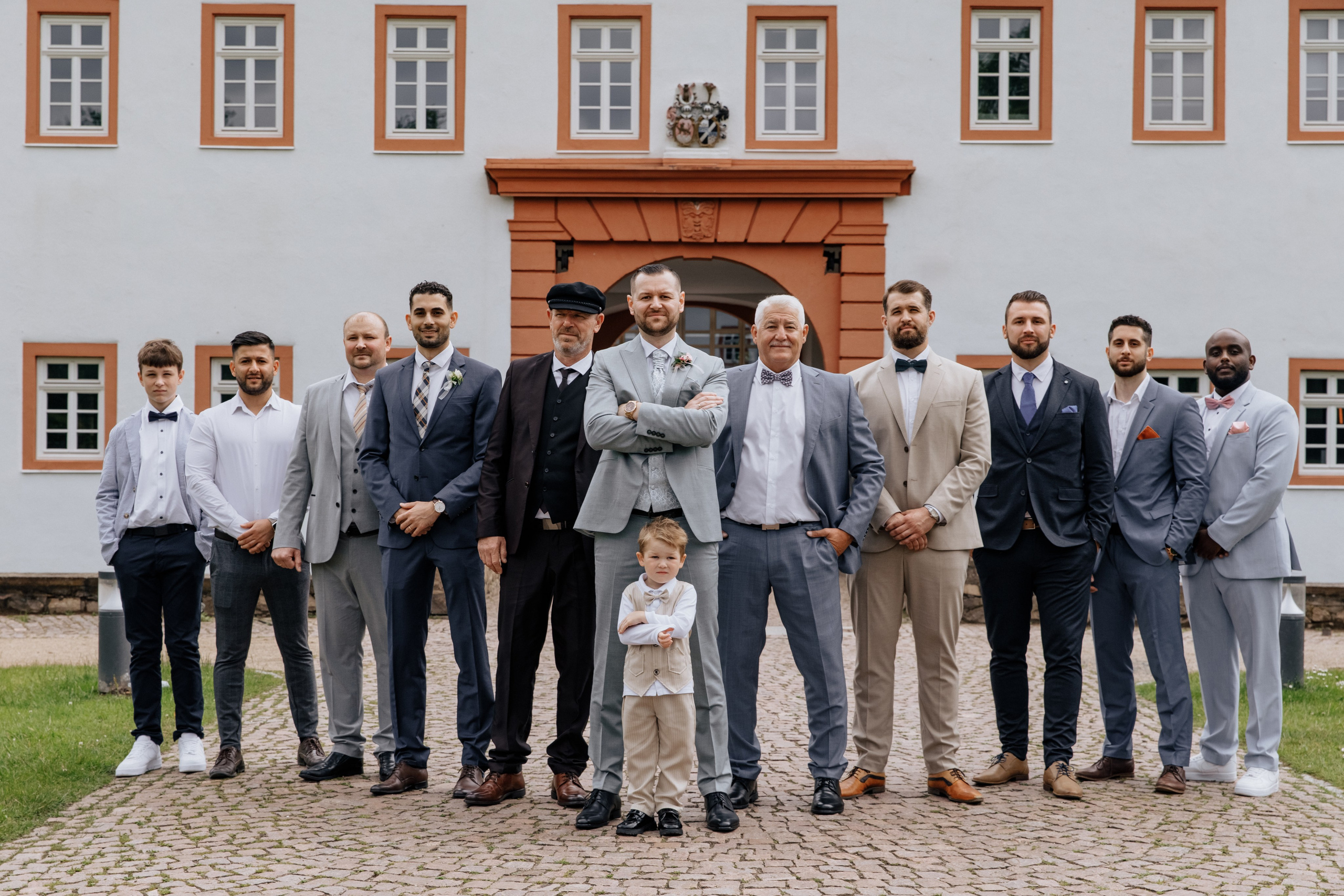 Der Bräutigam steht in der Mitte mit verschränkten Armen, während seine Freunde in einem V-Form um ihn herum stehen.