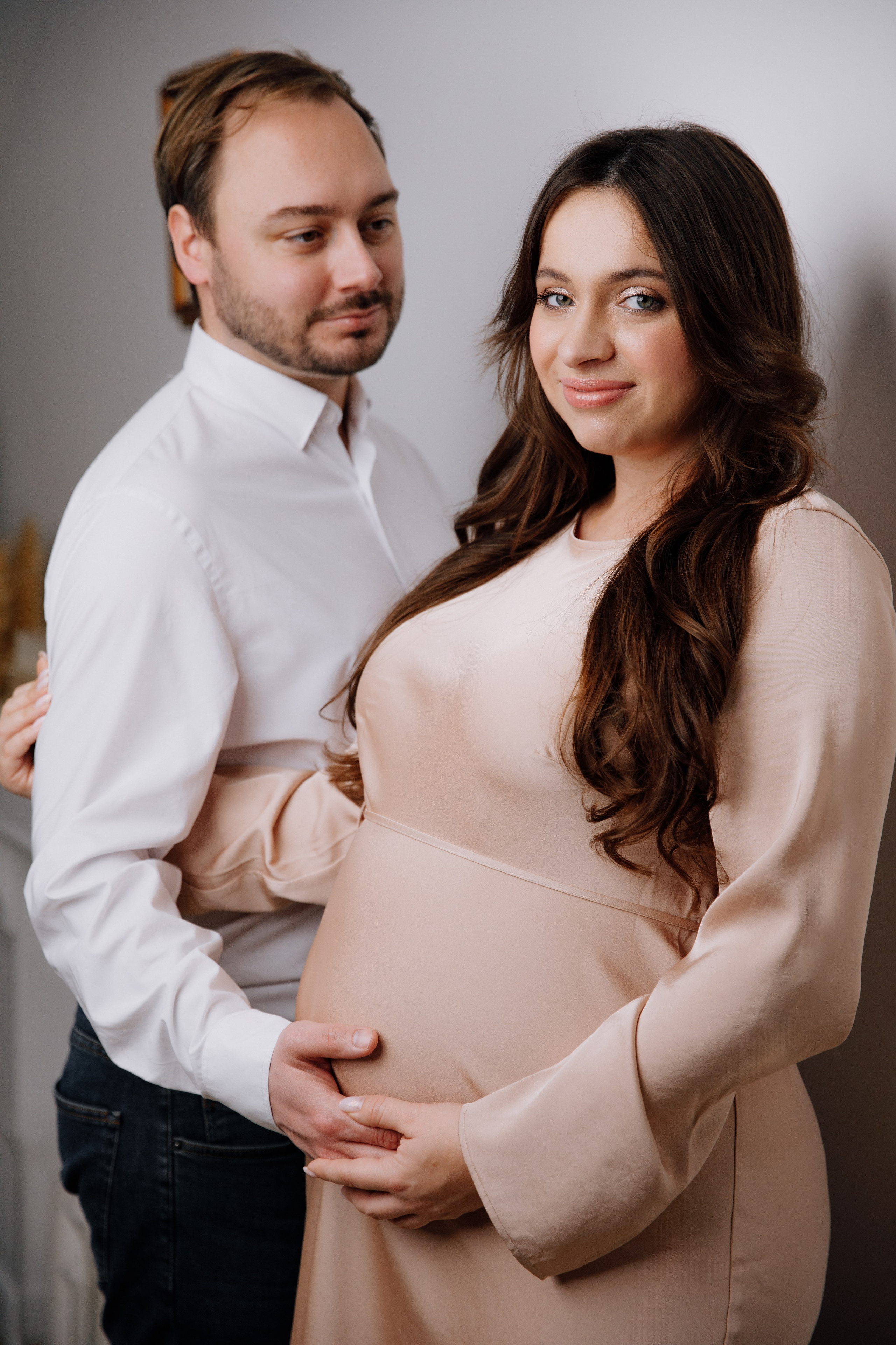 Mann schaut liebevoll auf seine schwangere Frau während eines emotionalen Schwangerschaftsshootings im Studio im Aschaffenburg.