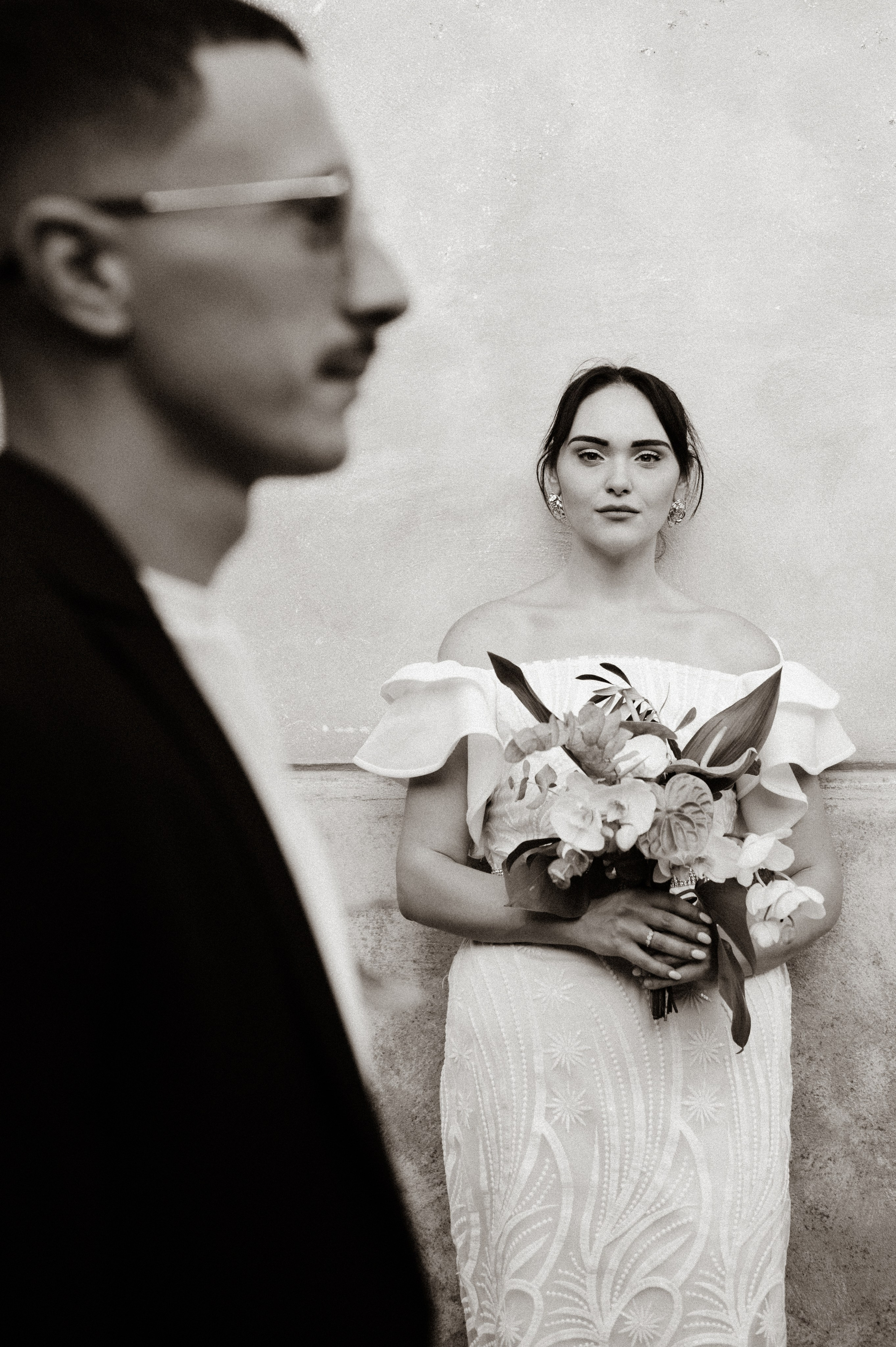 Ritratto di matrimonio naturale ed editoriale a Ravello con la sposa a fuoco e lo sposo delicatamente sfocato in primo piano. Fotografo Amalfi, Positano, Sorrento, Capri