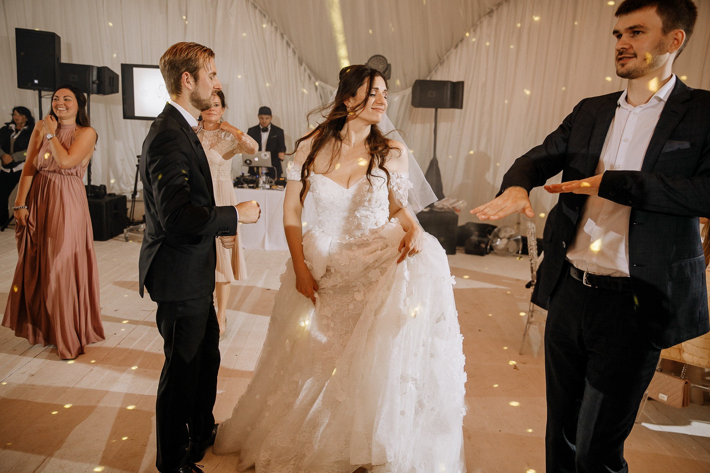 Bride dancing with friends, by Bude, Cornwall wedding photographer.