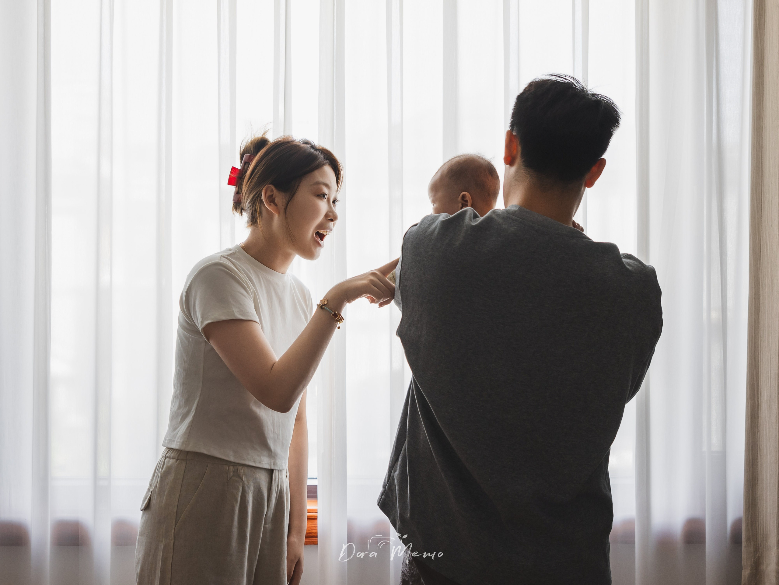 A Shanghai family photographer captures new parents sharing a joyful moment with their baby