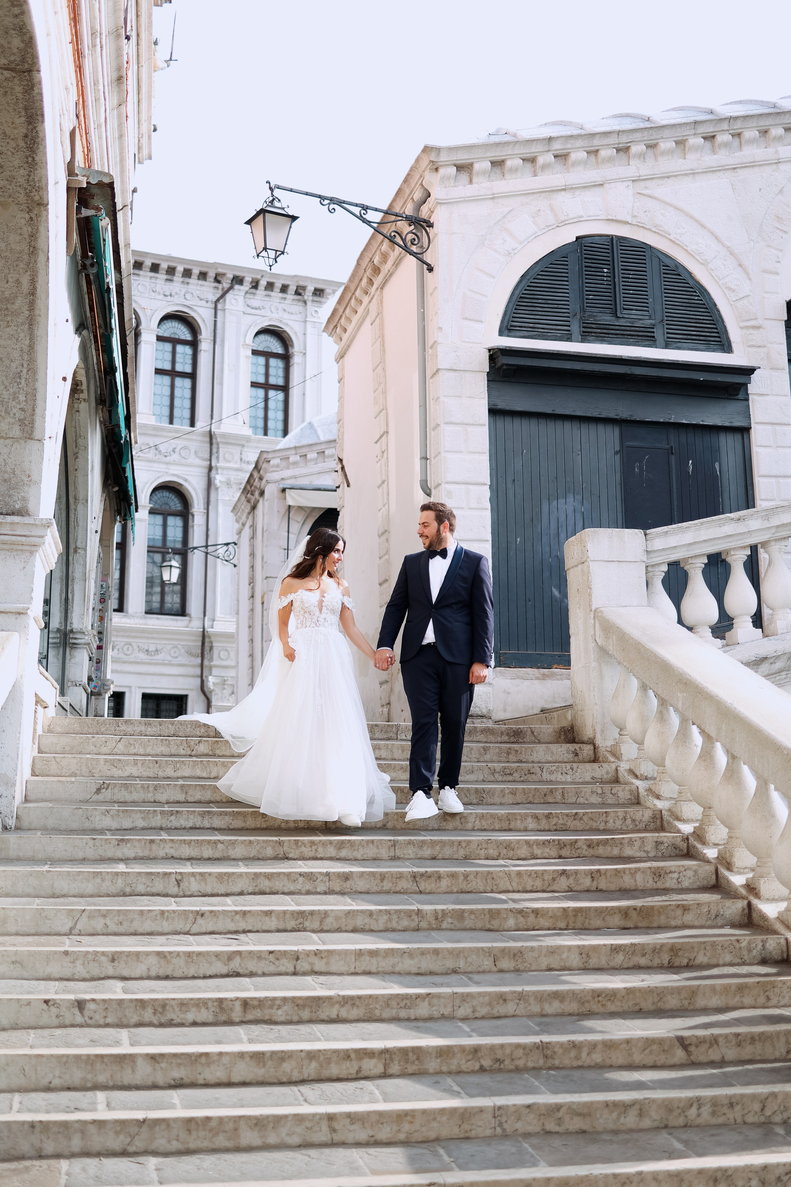the bride and groom walk down the steps of the Rialto Bridge
