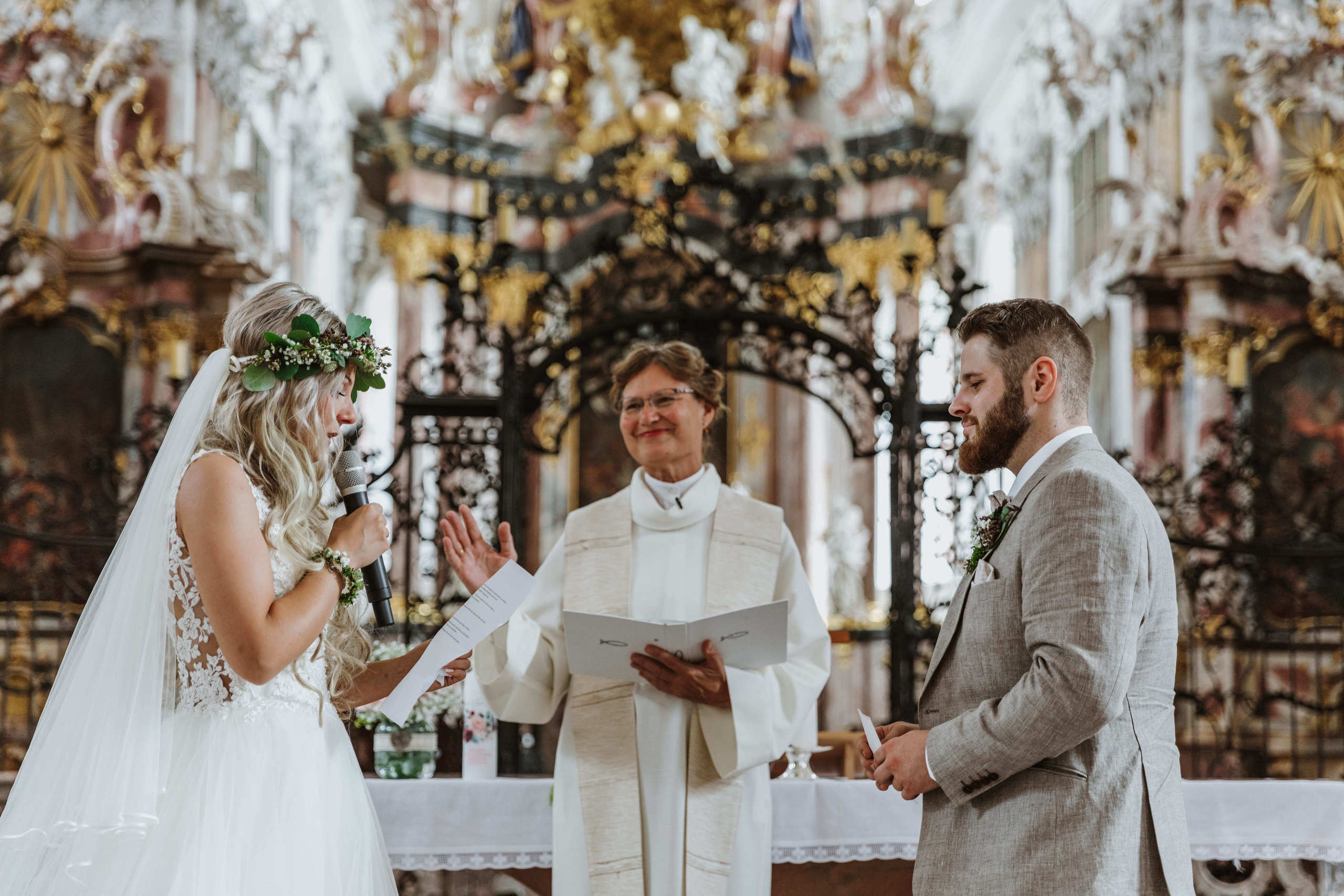 Braut und Bräutigam stehen vor dem Altar und sprechen ihr Eheversprechen.
