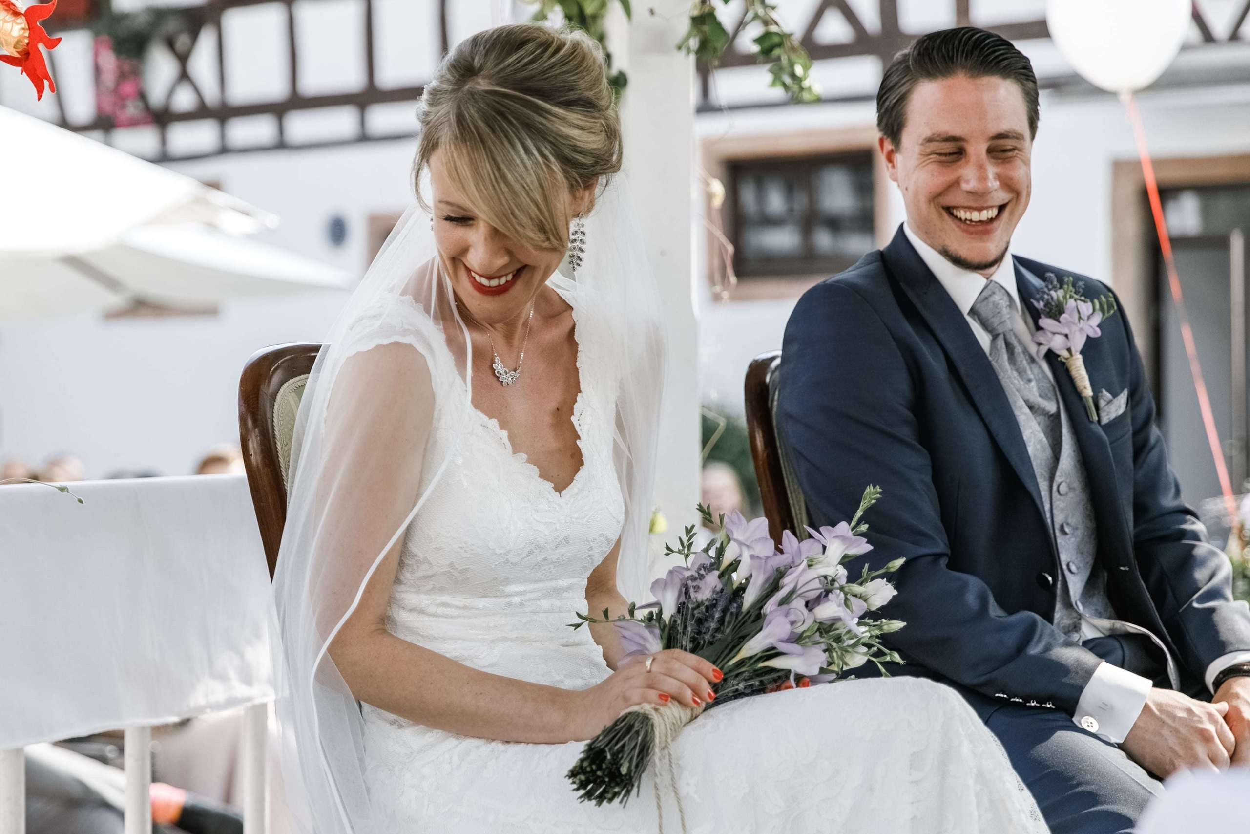 Braut lacht schüchtern während der freien Trauung.