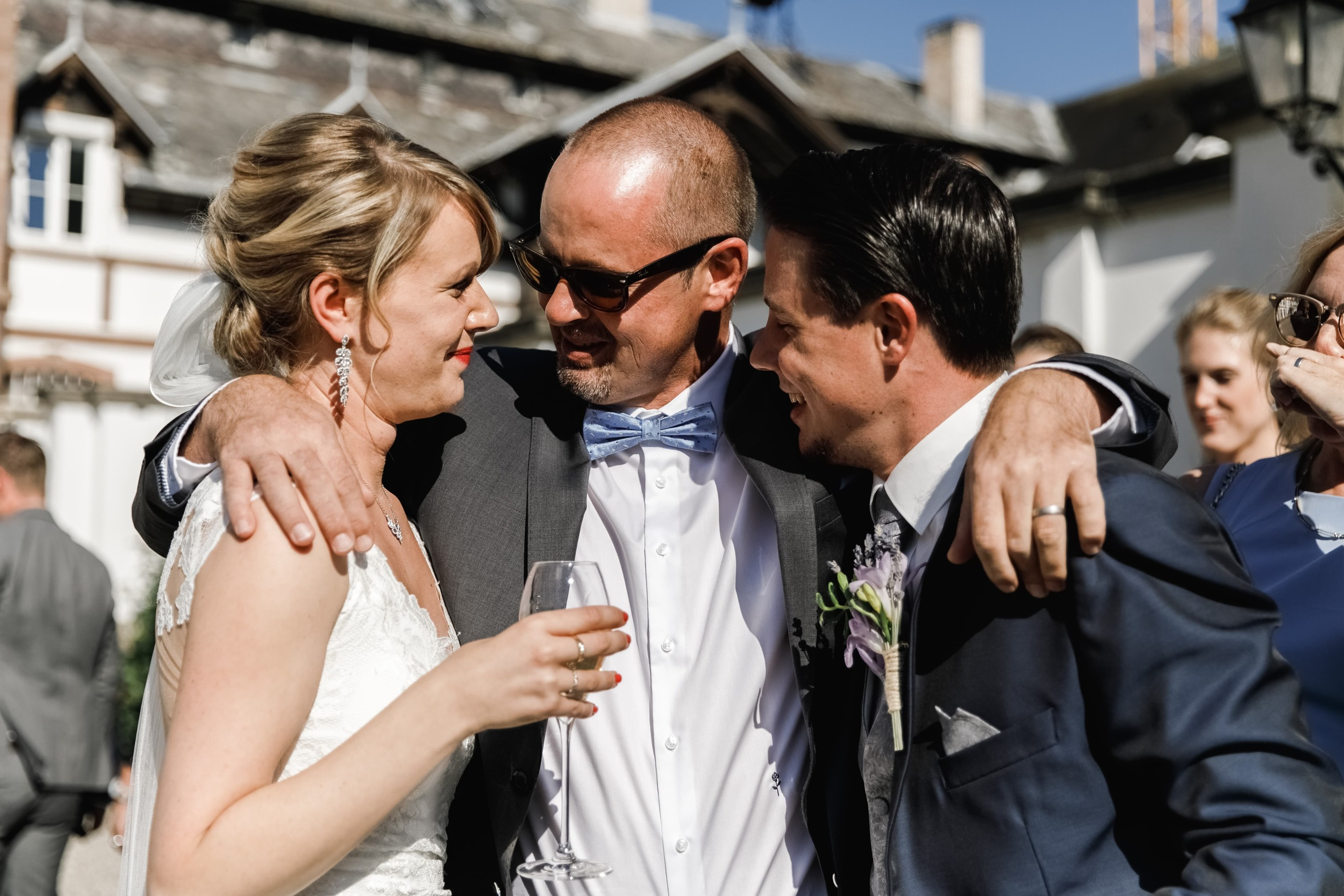 Hochzeitsgäste umarmen das Brautpaar nach der Zeremonie.