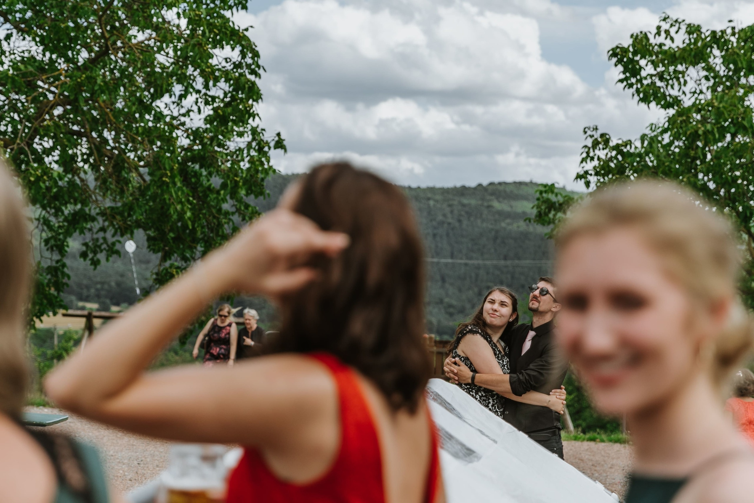 Die Gäste umarmen sich und schauen auf die fliegenden Hochzeitsballons.