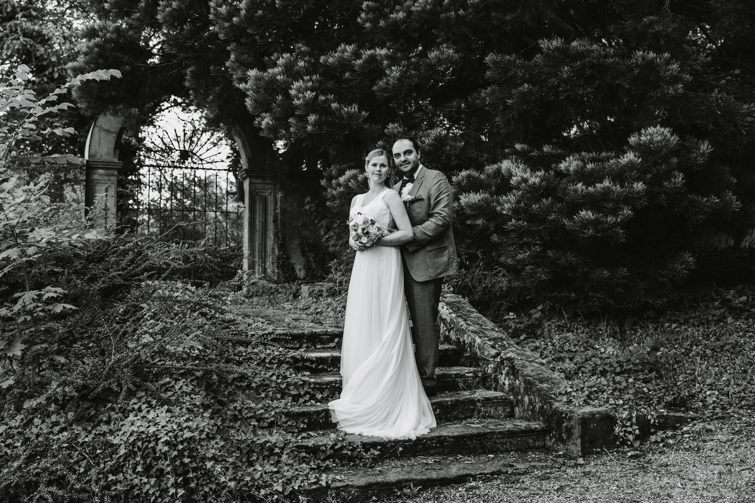 Bräutigam umarmt die Braut im Park von Schloss Castell.