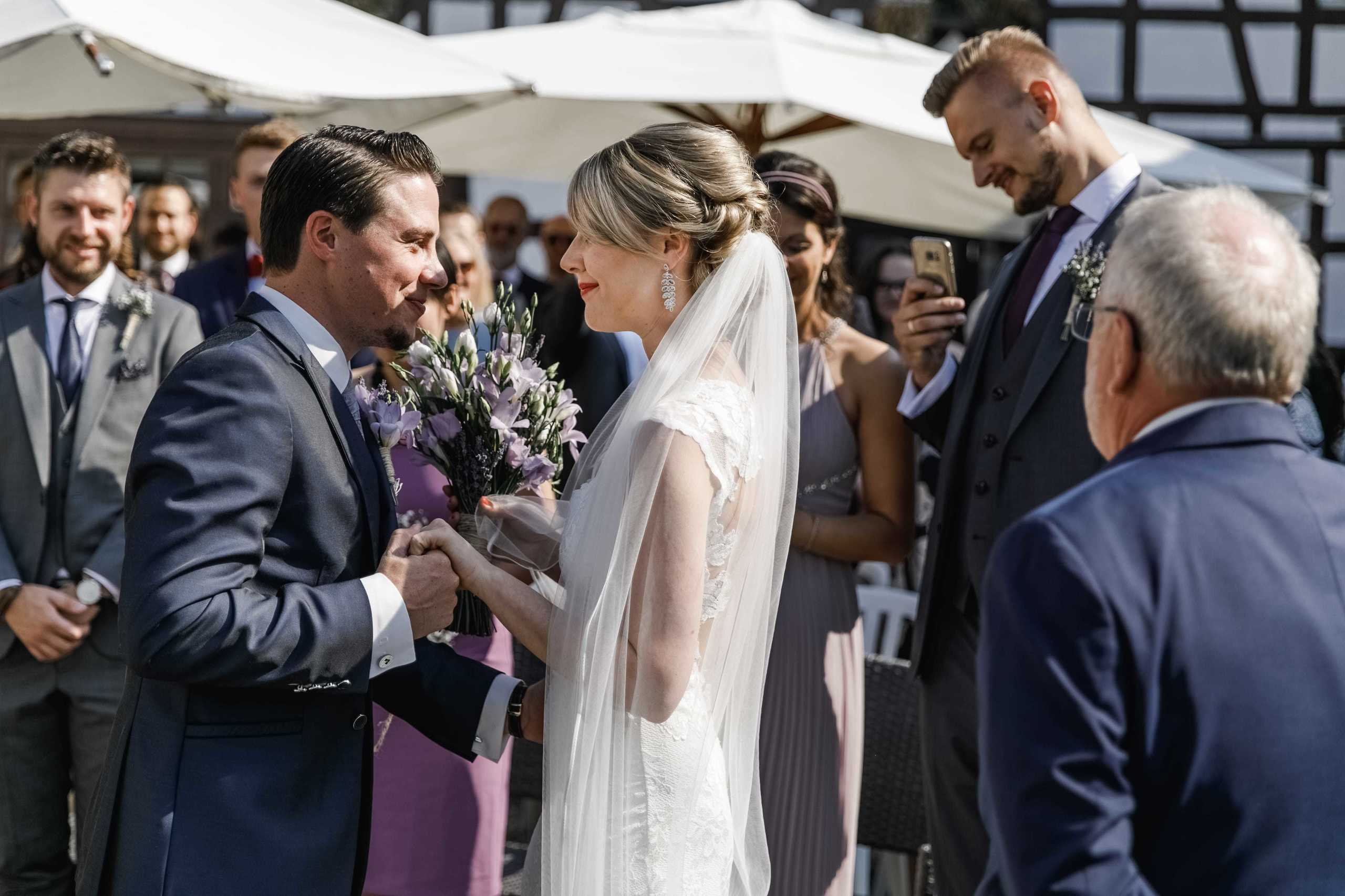 Bräutigam sieht die Braut zum ersten Mal im Hochzeitskleid am Altar – beide strahlen vor Glück.