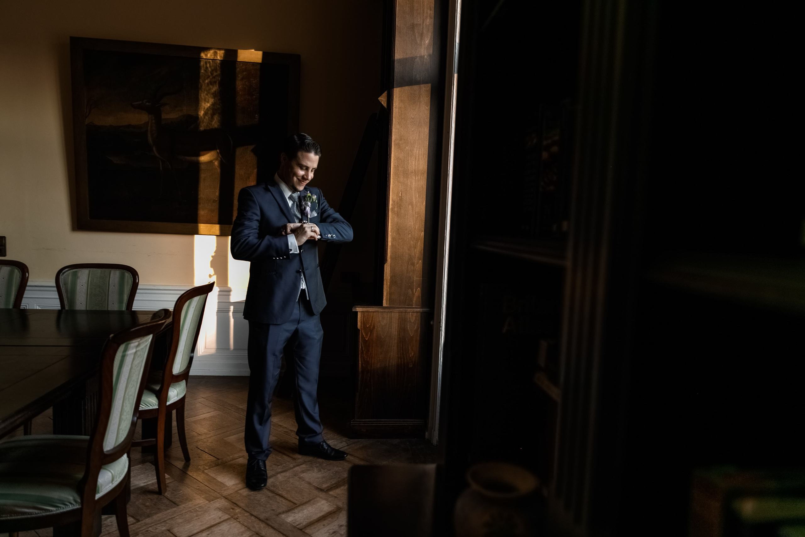 Der Bräutigam steht am Fenster und bereitet sich auf die Zeremonie vor.