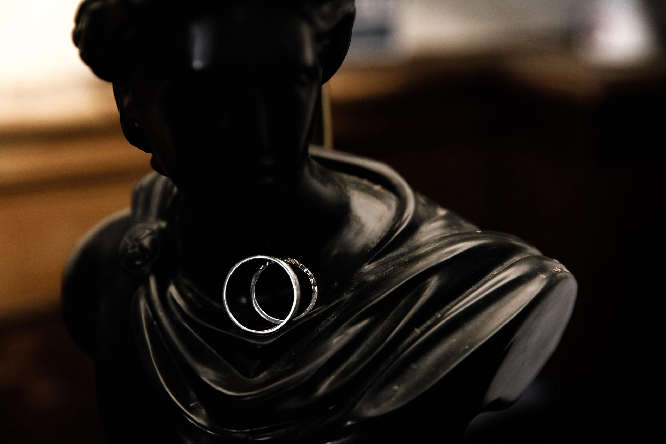 Die Eheringe liegen auf einer antiken Statue.