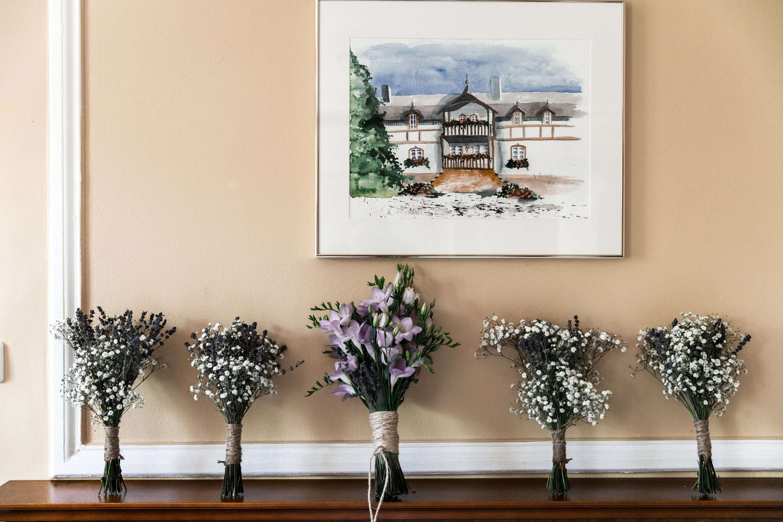 Brautstrauß und Brautjungfernsträuße an der Wand.