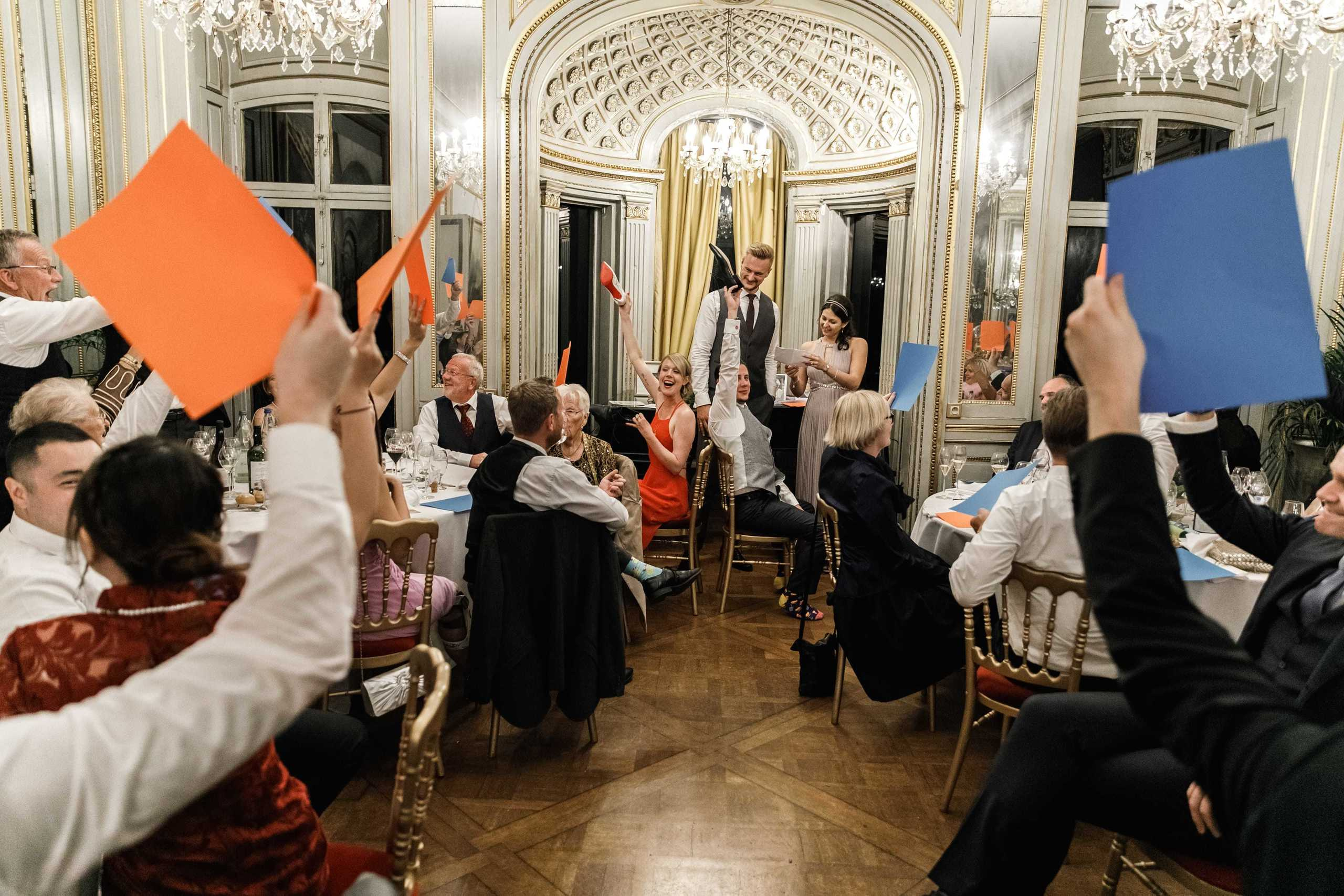 Die Hochzeitsgesellschaft spielt mit dem Brautpaar ein Kartenspiel.