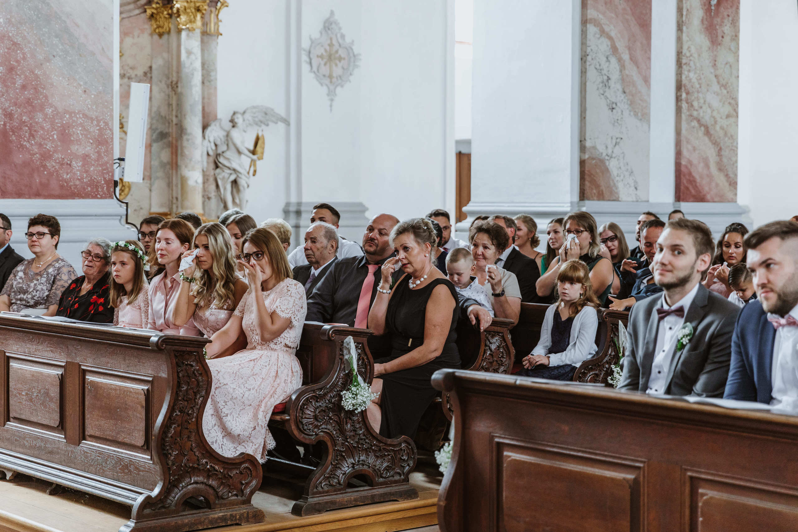 Gäste weinen und lächeln gerührt während der Zeremonie.