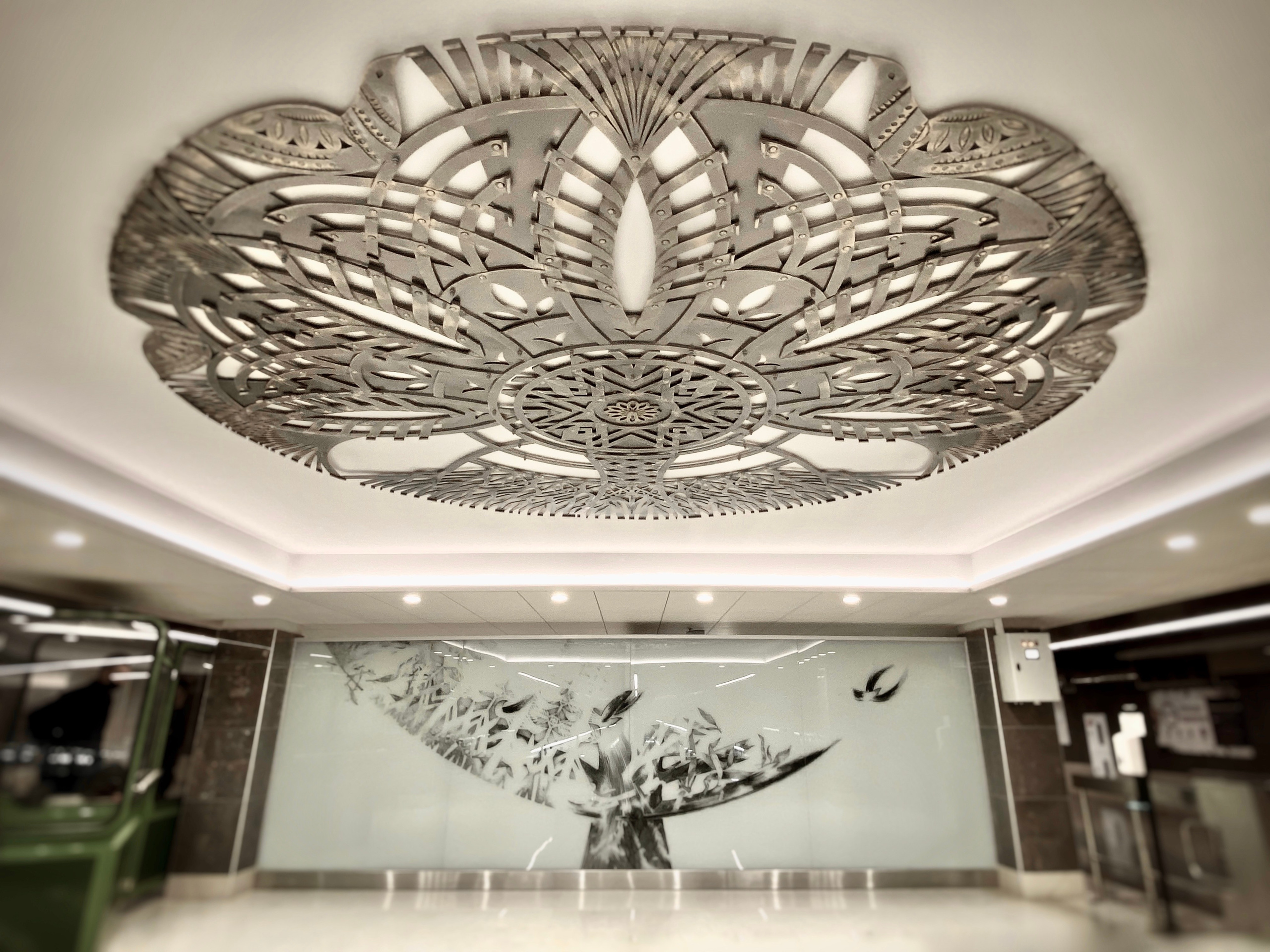 Минское Метро. Станция «Ковальская слобода». 2019-2020 «КАВАЛЬСКIЯ ВЫЦIНАНКI» кованые подвесные светотеневые композиции, декоративные элементы. Сталь, художественная ковка, лазерная резка, сварка. Художники Мария Тарлецкая, Павел Войницкий, Архитекторы Владимир Телепнёв, Ольга Телепнёва, Анна Кузмич. По мотивам произведений Елизаветы Червонцевой и Молодечненской школы вытинанки. Кассы, кассовый зал.